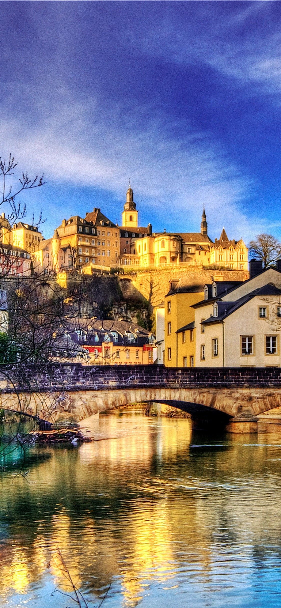 Bâtiment en Béton Brun Près D'un Plan D'eau Sous un Ciel Bleu Pendant la Journée. Wallpaper in 1125x2436 Resolution