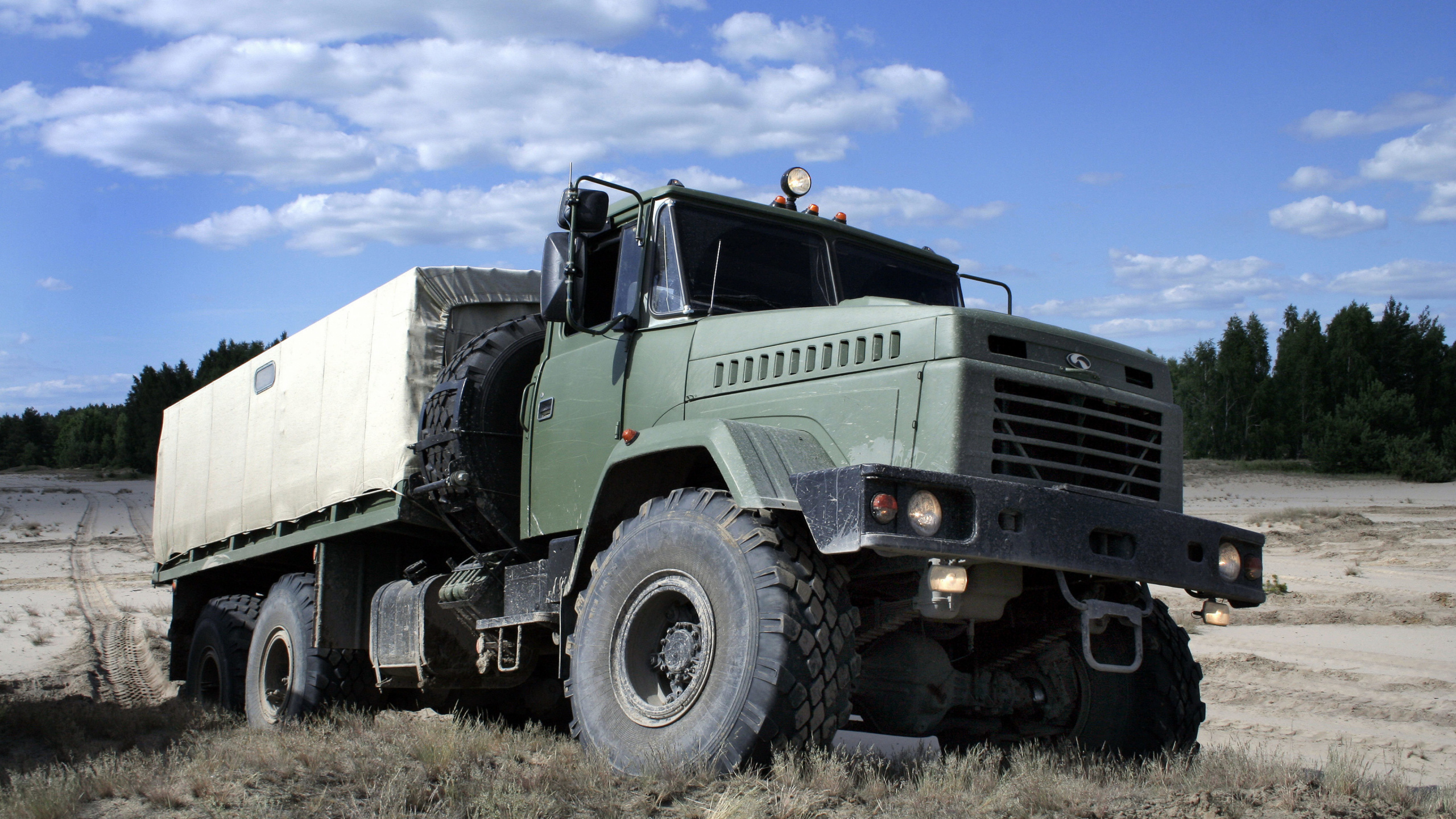 Green and White Truck on Brown Grass Field Under Blue Sky During Daytime. Wallpaper in 2560x1440 Resolution