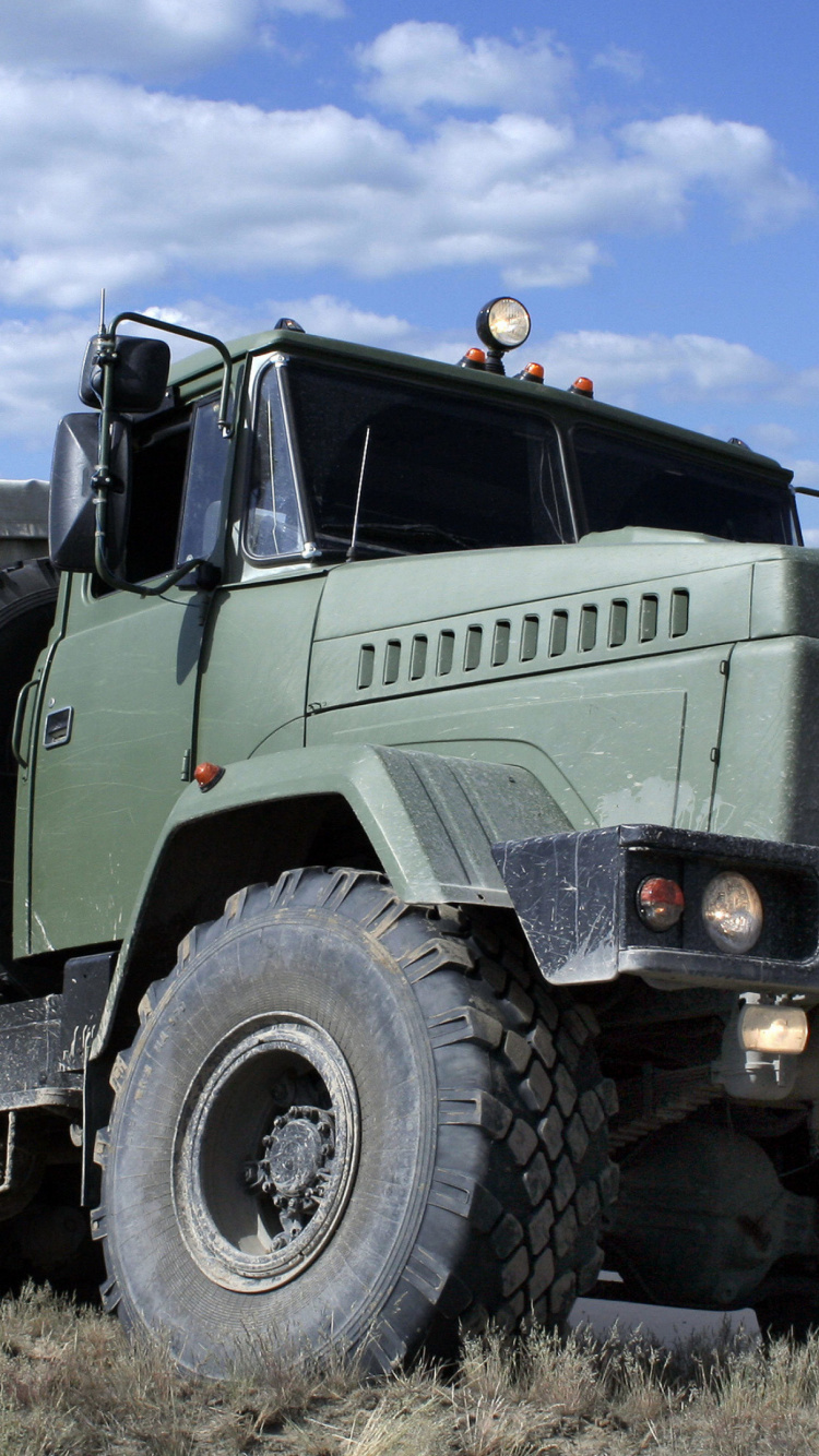 Grün-weißer LKW Auf Brauner Wiese Unter Blauem Himmel Tagsüber. Wallpaper in 750x1334 Resolution