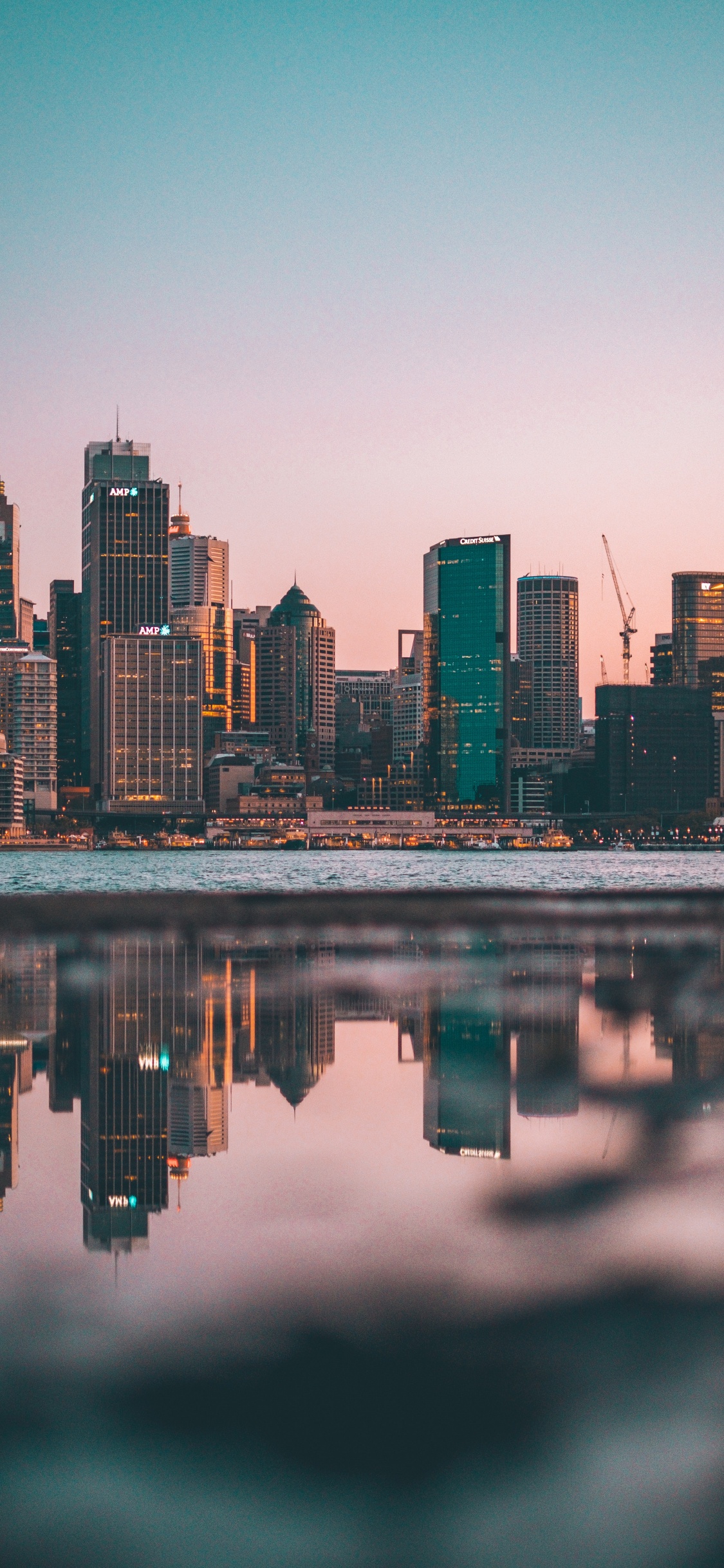 City Skyline Across Body of Water During Night Time. Wallpaper in 1125x2436 Resolution