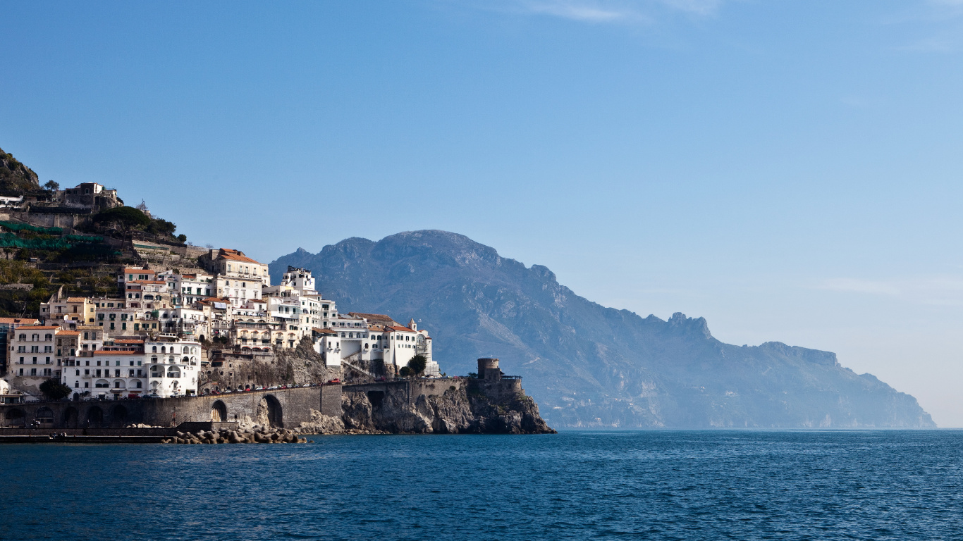 White and Brown Concrete Building Near Body of Water During Daytime. Wallpaper in 1366x768 Resolution