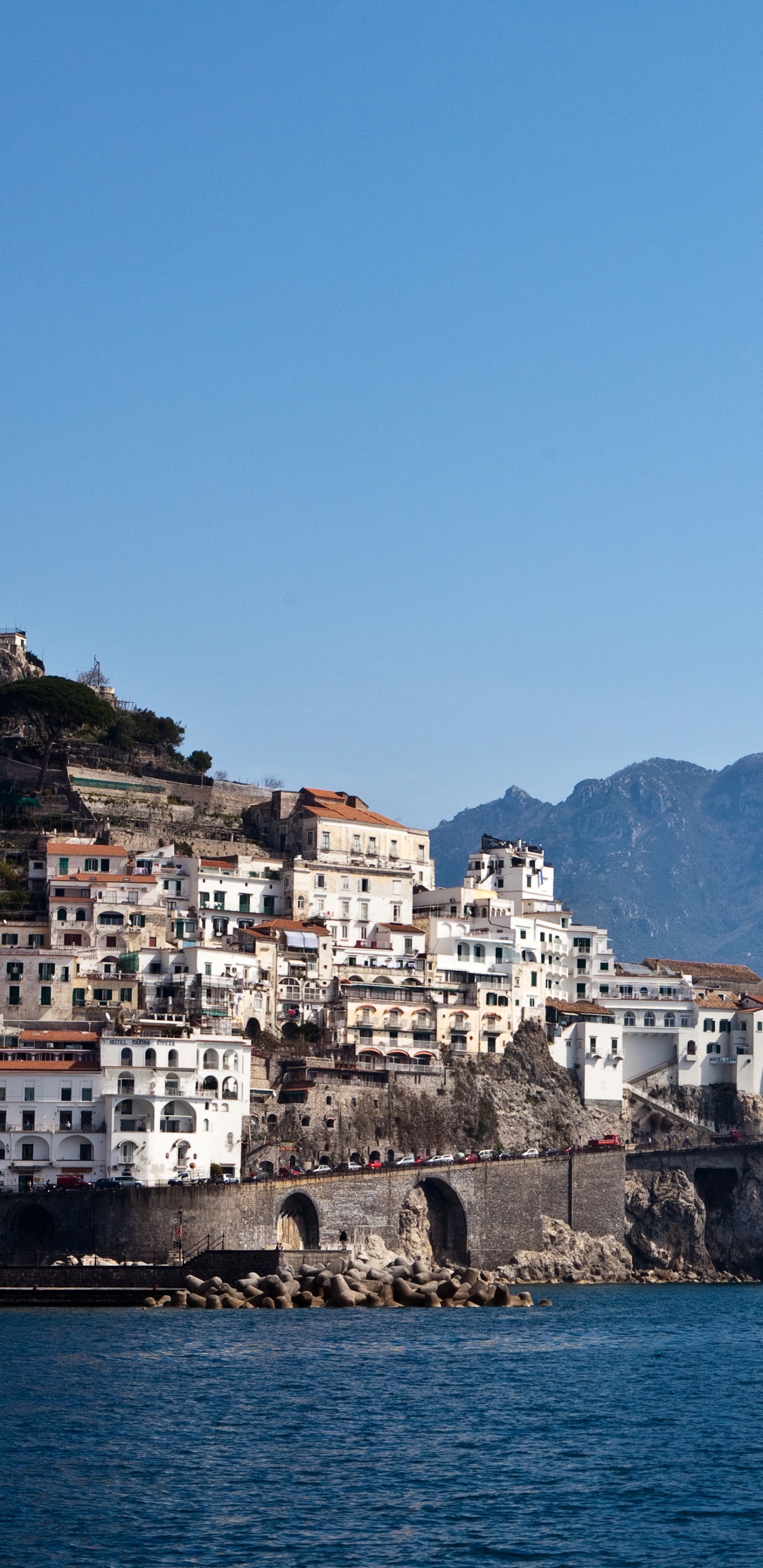 Edificio de Hormigón Blanco y Marrón Cerca Del Cuerpo de Agua Durante el Día. Wallpaper in 1440x2960 Resolution