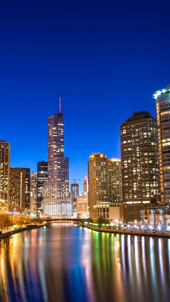 Skyline Der Stadt Über Gewässer Während Der Nacht. Wallpaper in 720x1280 Resolution