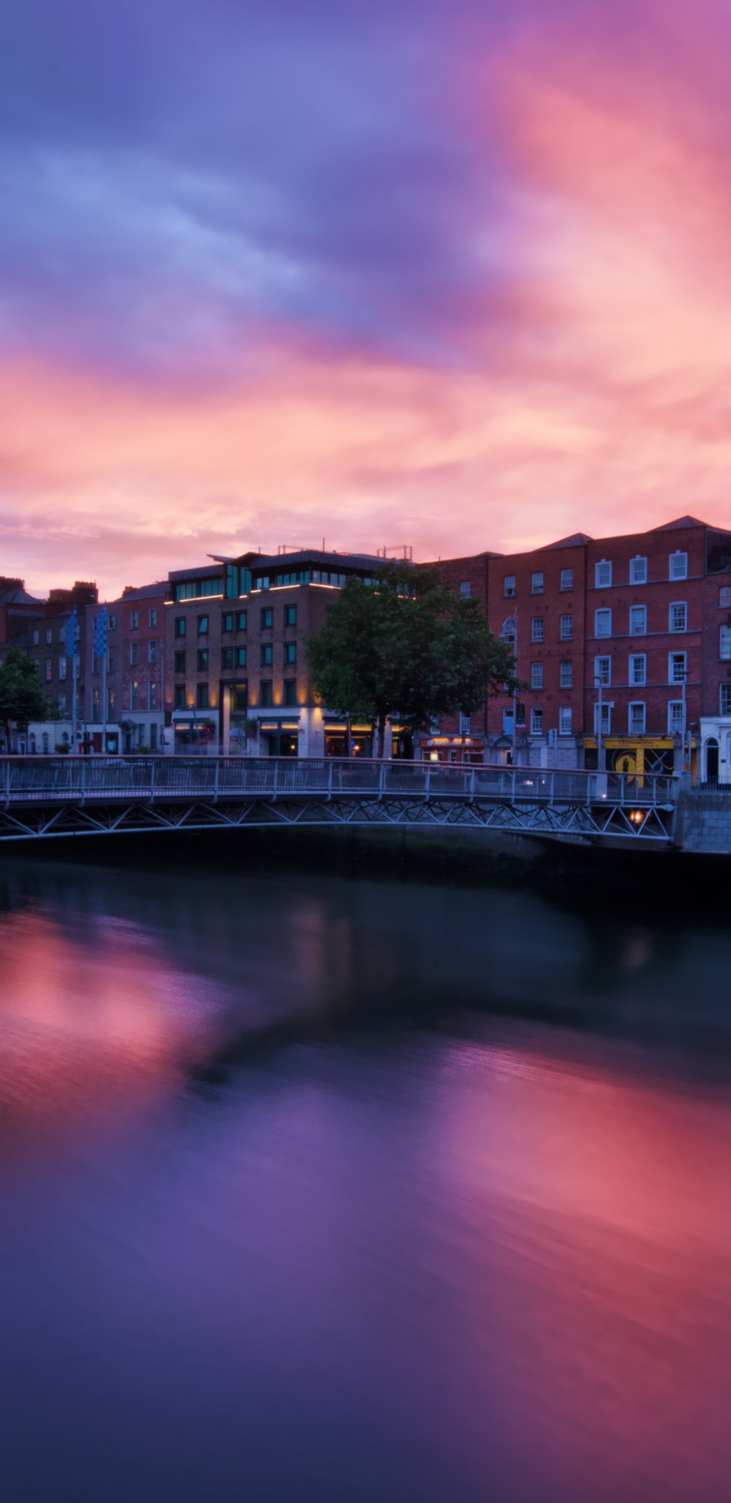 Skyline Der Stadt in Der Nähe Von Gewässern Bei Sonnenuntergang. Wallpaper in 1440x2960 Resolution