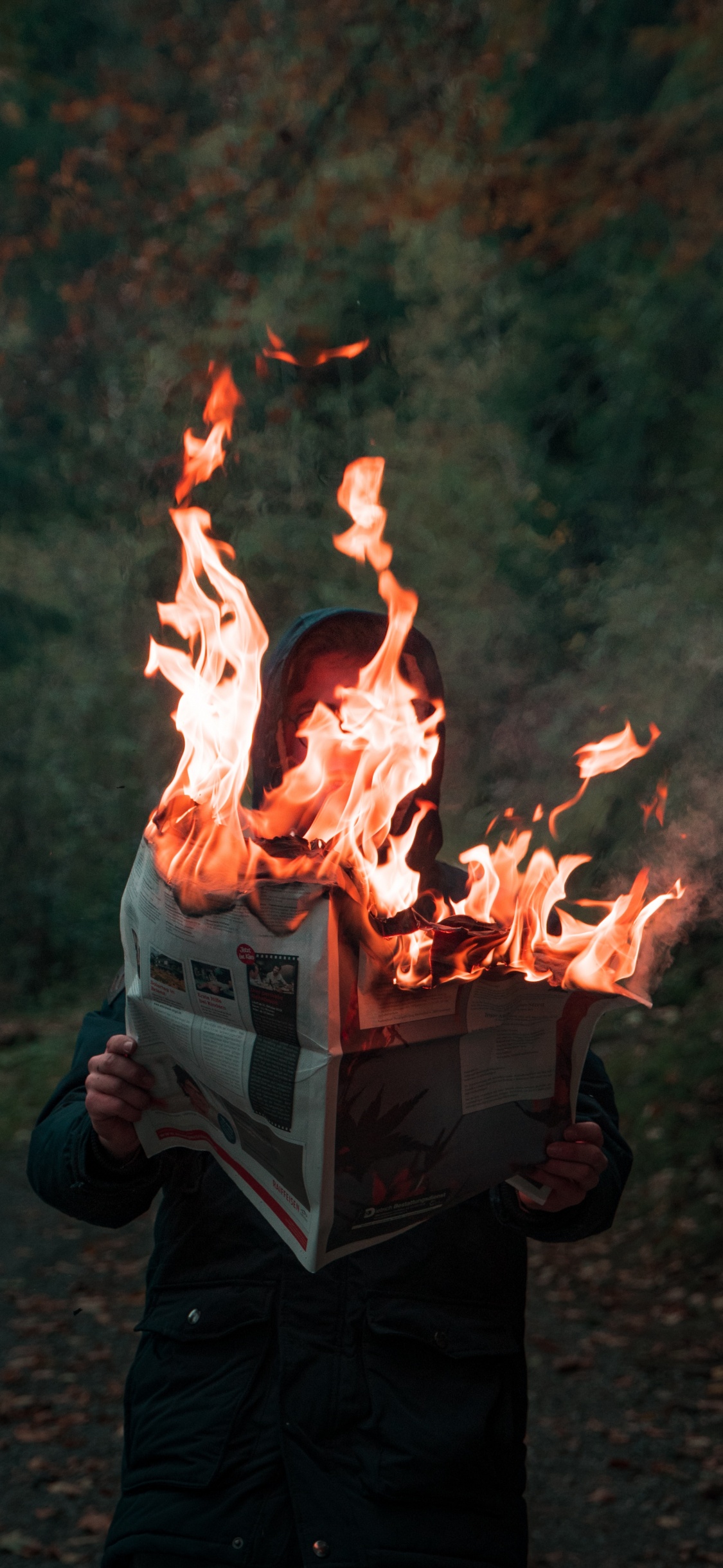 Person in Black Jacket Holding Fire. Wallpaper in 1125x2436 Resolution