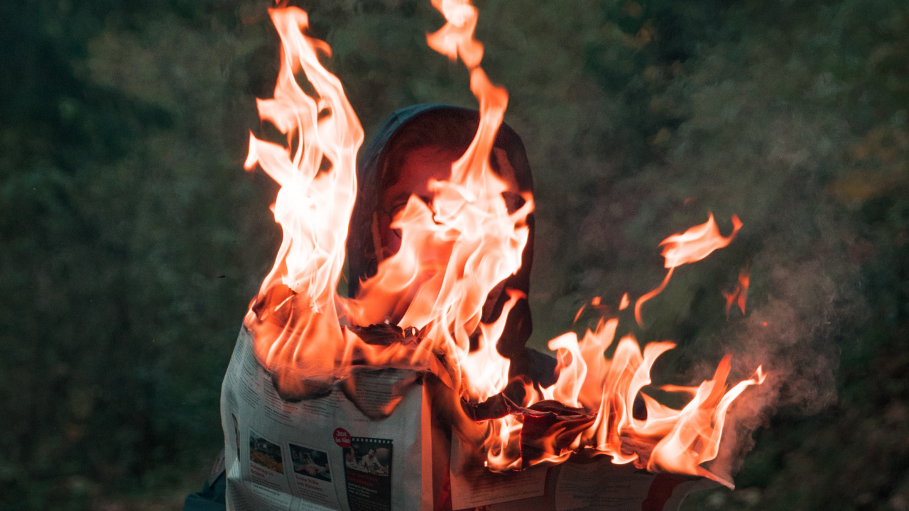 Person in Black Jacket Holding Fire. Wallpaper in 1280x720 Resolution