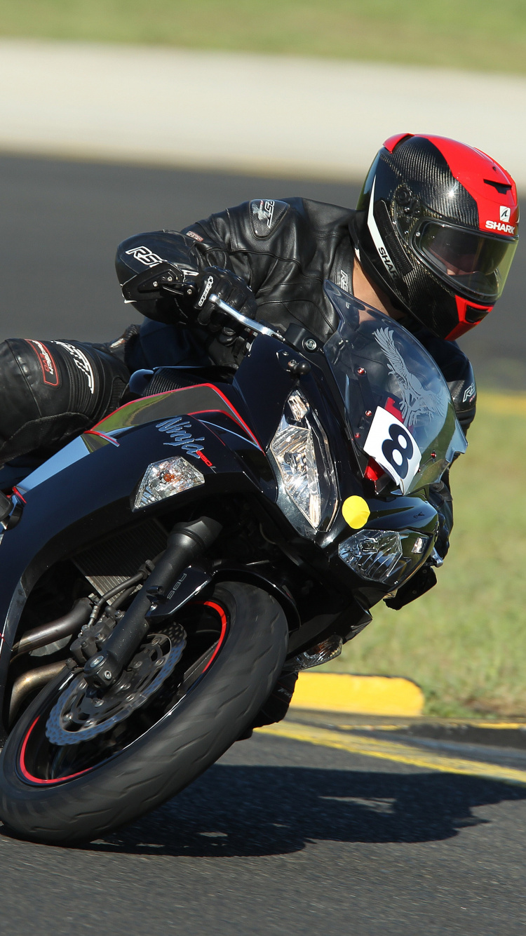 Homme en Costume de Moto Noir et Blanc à Cheval Sur un Vélo de Sport Noir et Blanc. Wallpaper in 750x1334 Resolution