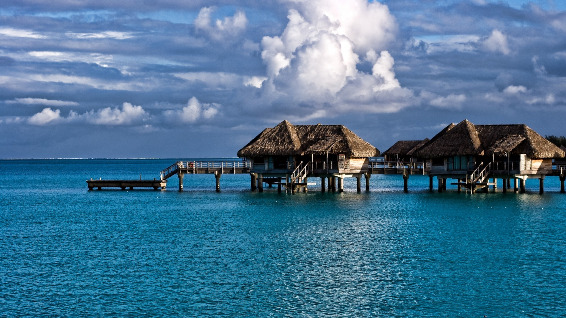 Brown Wooden Houses on Blue Sea Under Blue Sky During Daytime. Wallpaper in 1920x1080 Resolution