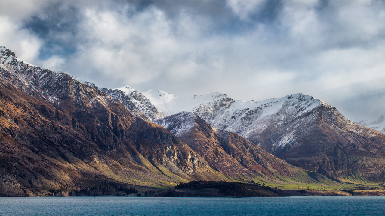 Snow Covered Mountain Near Body of Water During Daytime. Wallpaper in 1280x720 Resolution