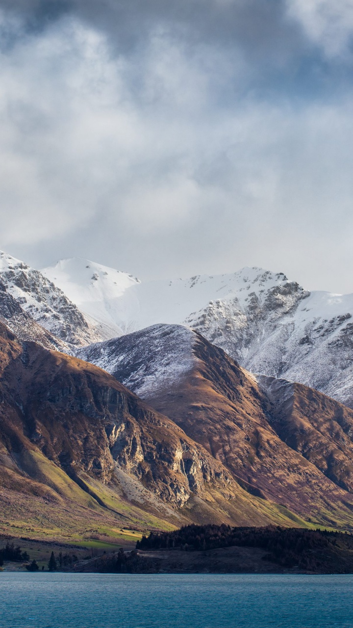 Snow Covered Mountain Near Body of Water During Daytime. Wallpaper in 720x1280 Resolution