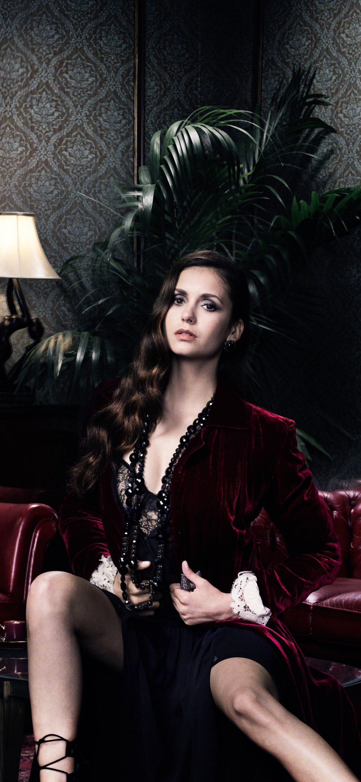 Femme en Robe Noire Assise Sur un Canapé Rouge. Wallpaper in 1242x2688 Resolution