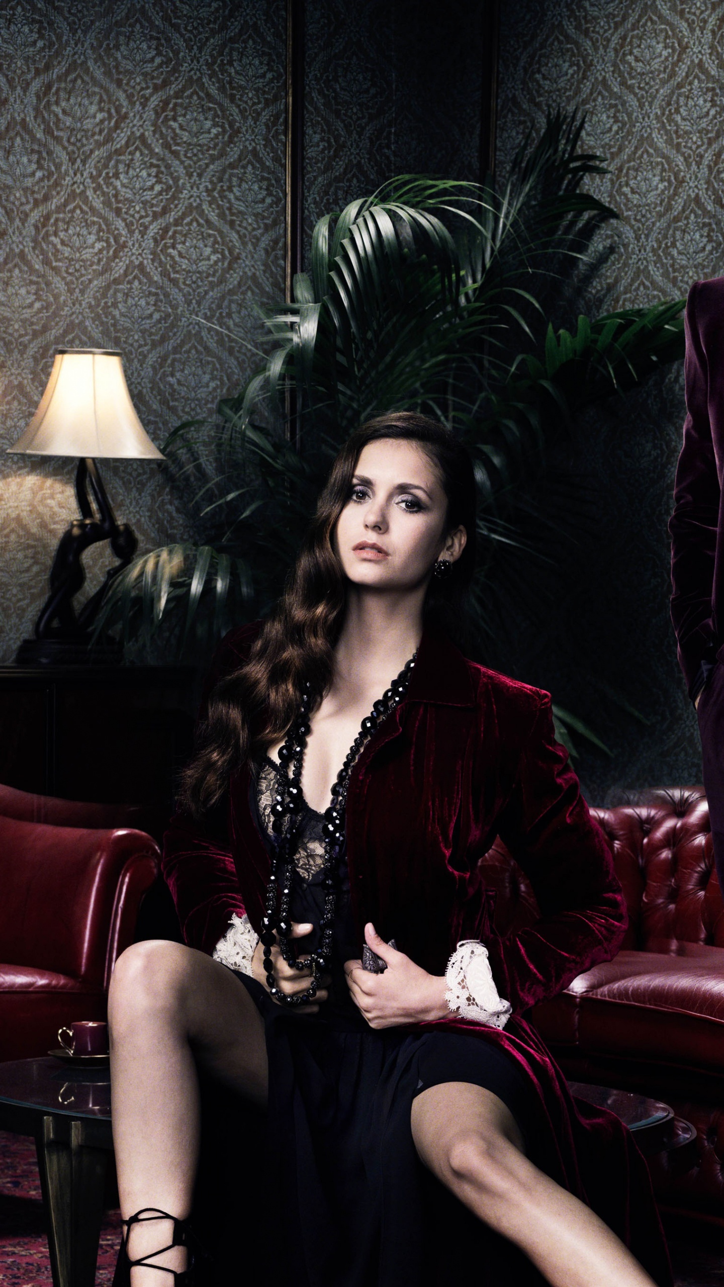 Woman in Black Dress Sitting on Red Couch. Wallpaper in 1440x2560 Resolution