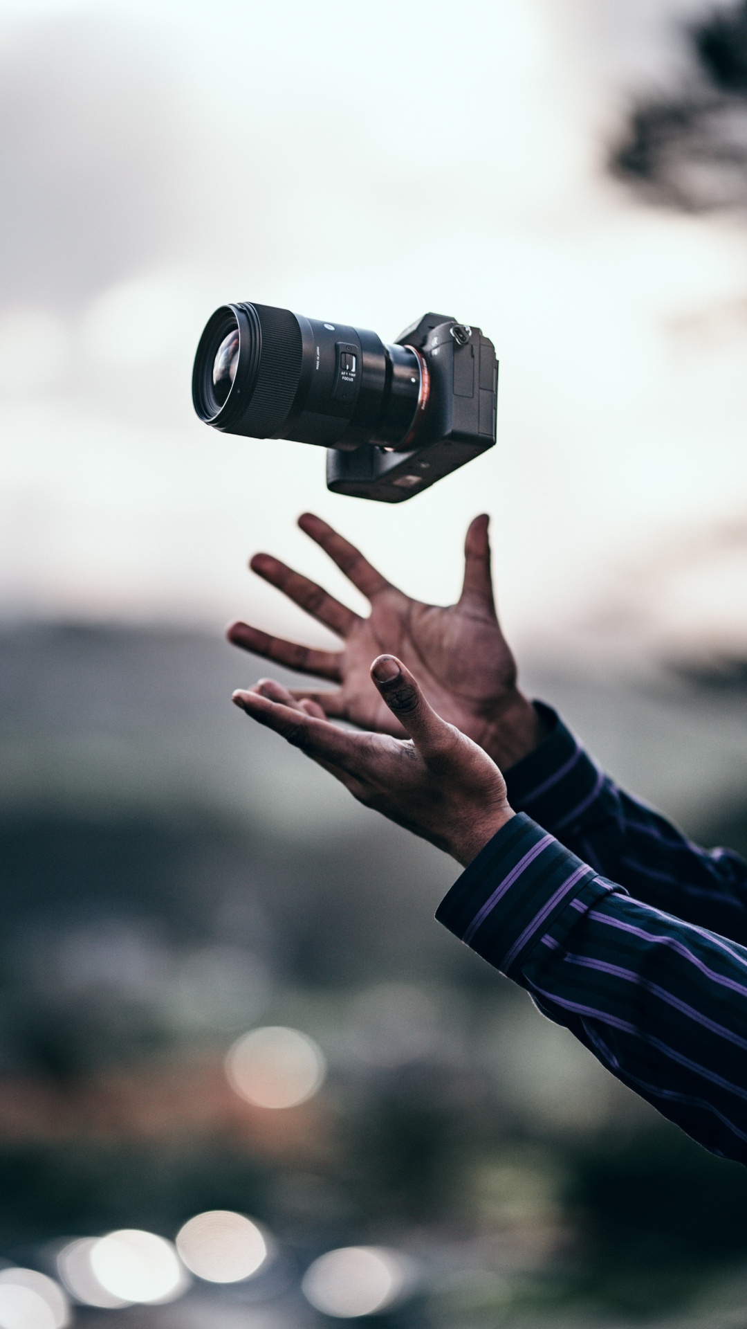 Person in Black Long Sleeve Shirt Holding Black Dslr Camera. Wallpaper in 1080x1920 Resolution