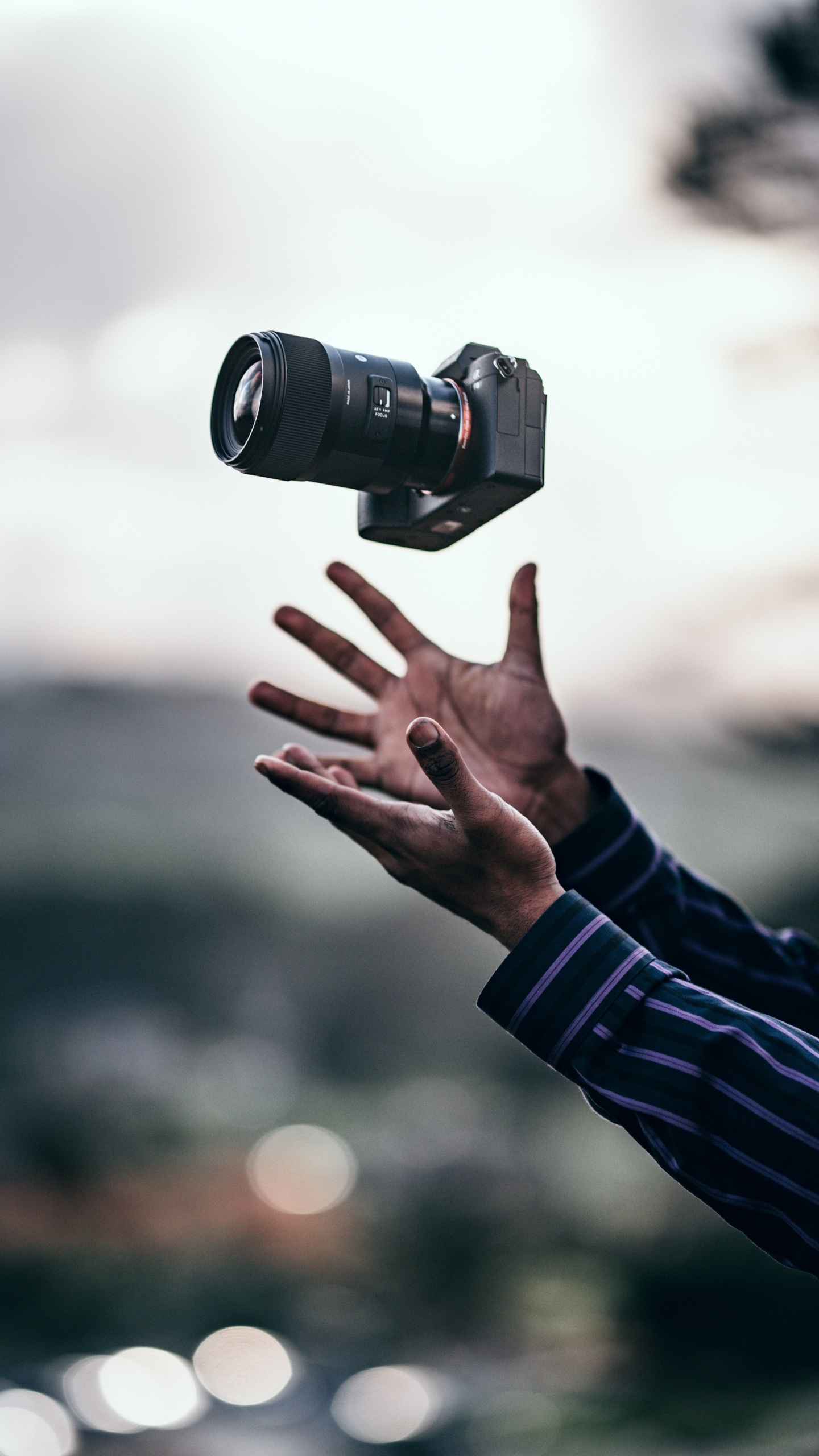 Person in Black Long Sleeve Shirt Holding Black Dslr Camera. Wallpaper in 1440x2560 Resolution