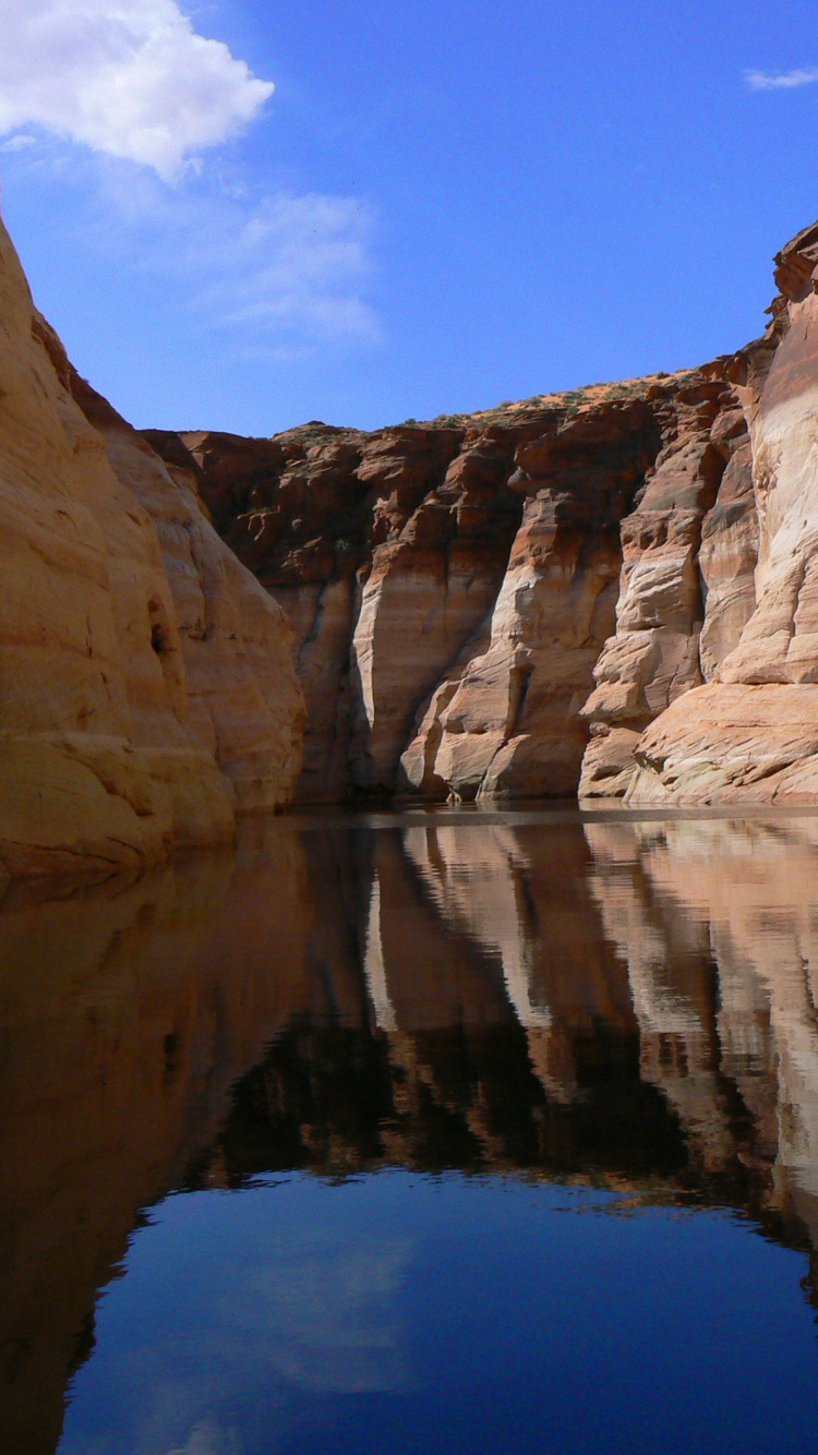 Brown Rock Formation Near Body of Water Under Blue Sky During Daytime. Wallpaper in 750x1334 Resolution