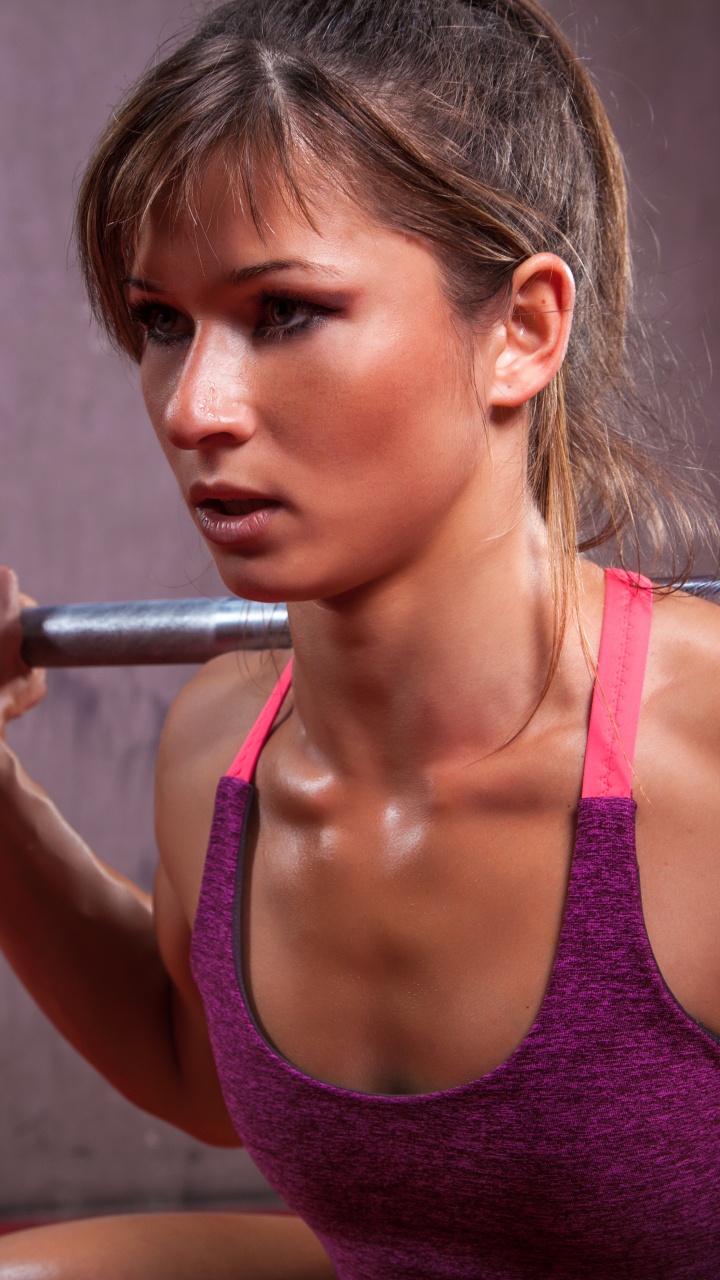Woman in Pink Tank Top Holding Barbell. Wallpaper in 720x1280 Resolution