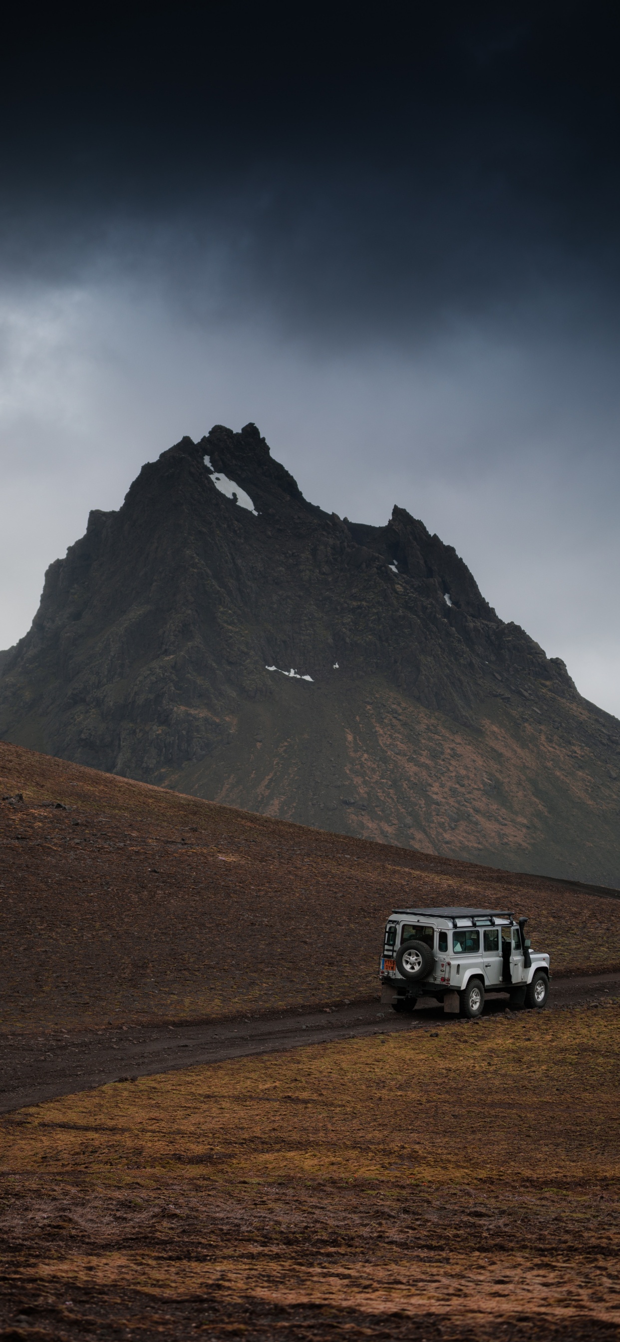 SUV Blanco en Campo Marrón Cerca de la Montaña Bajo un Cielo Blanco Durante el Día. Wallpaper in 1242x2688 Resolution