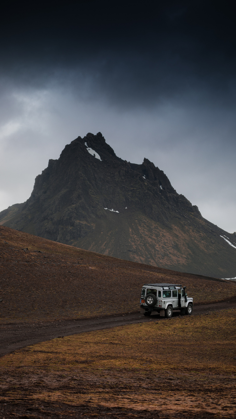 SUV Blanco en Campo Marrón Cerca de la Montaña Bajo un Cielo Blanco Durante el Día. Wallpaper in 750x1334 Resolution