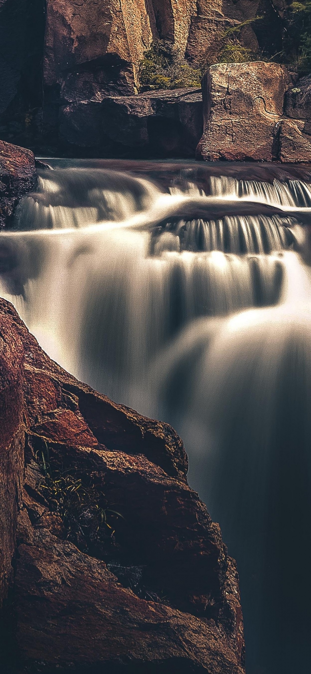 Cascadas en la Montaña Rocosa Marrón Durante el Día. Wallpaper in 1242x2688 Resolution