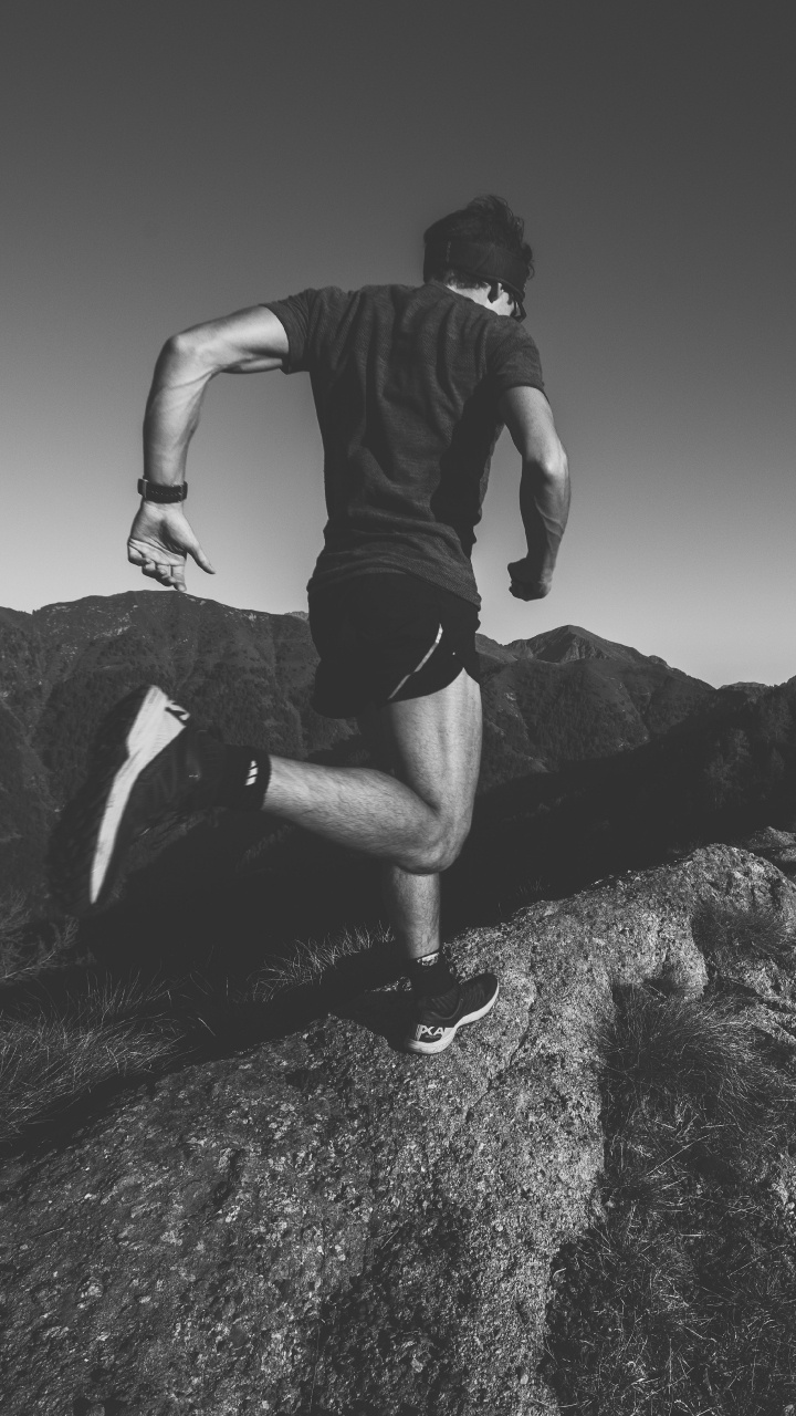 Man in Black T-shirt and Black Shorts Sitting on Rock. Wallpaper in 720x1280 Resolution