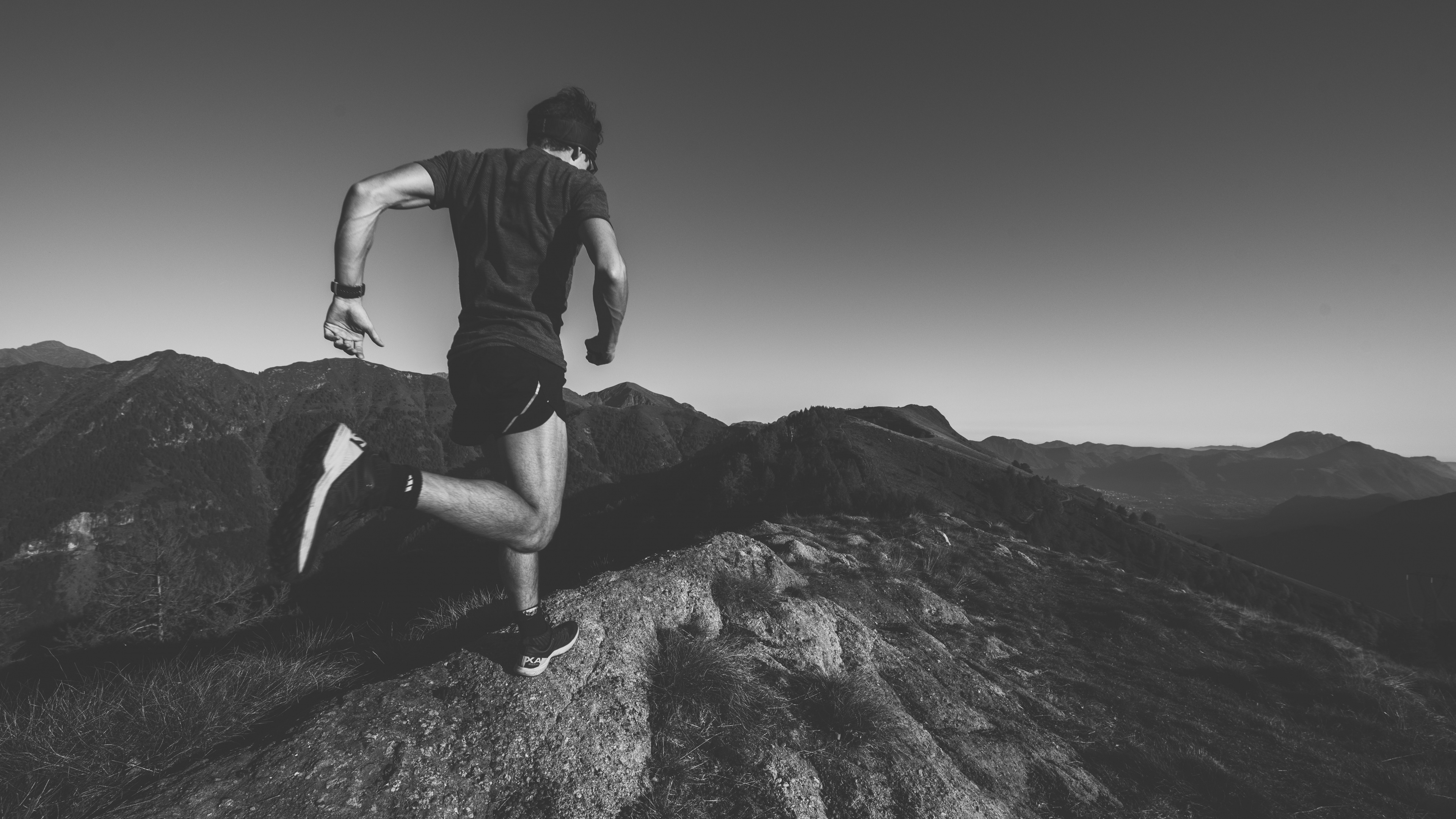 Mann in Schwarzem T-Shirt Und Schwarzen Shorts Sitzt Auf Felsen. Wallpaper in 3840x2160 Resolution