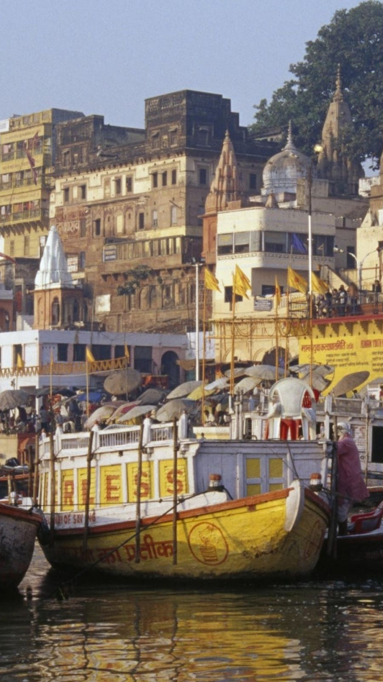 Barco Marrón y Blanco Sobre el Agua Cerca de Los Edificios de la Ciudad Durante el Día. Wallpaper in 750x1334 Resolution