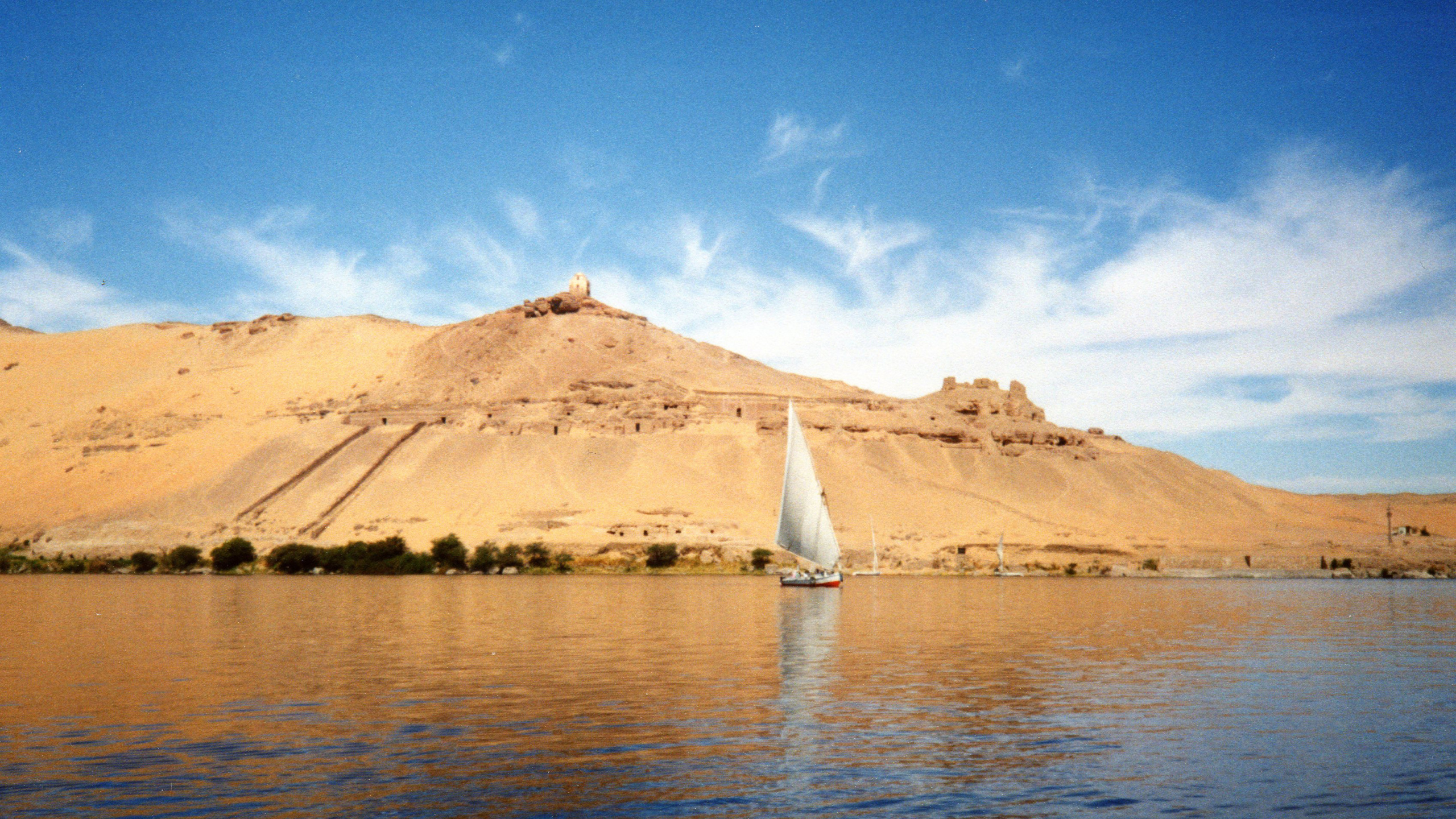 White Sailboat on Sea Near Brown Mountain Under Blue Sky During Daytime. Wallpaper in 2560x1440 Resolution