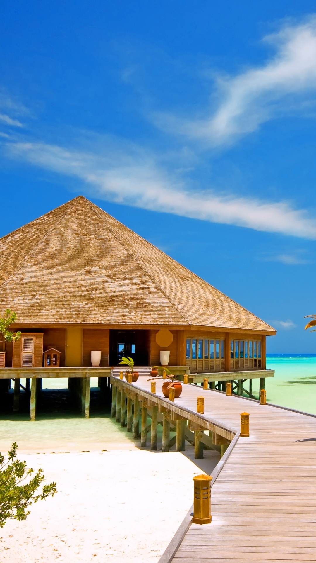 Maison de Plage en Bois Brun Sur la Plage Pendant la Journée. Wallpaper in 1080x1920 Resolution