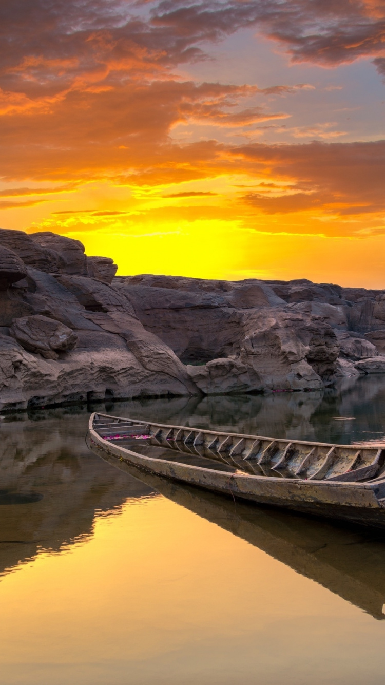 Graues Und Schwarzes Kanu Auf Gewässer Bei Sonnenuntergang. Wallpaper in 750x1334 Resolution