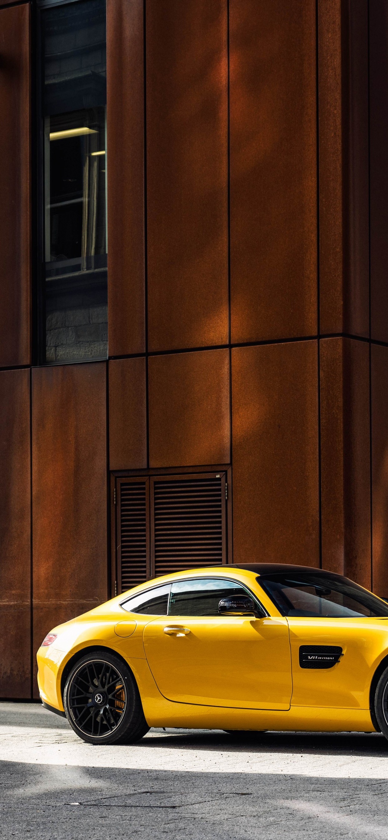 Porsche 911 Amarillo Estacionado Junto al Edificio de Hormigón Marrón Durante el Día. Wallpaper in 1242x2688 Resolution