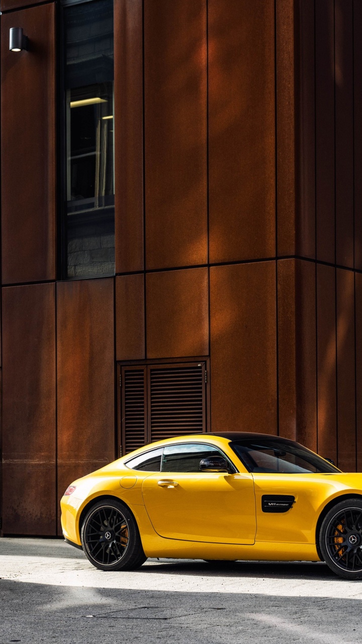 Porsche 911 Amarillo Estacionado Junto al Edificio de Hormigón Marrón Durante el Día. Wallpaper in 720x1280 Resolution