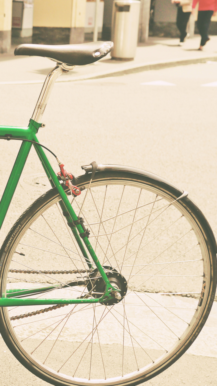 Grünes Fahrrad, Das Tagsüber Auf Dem Bürgersteig Geparkt Ist. Wallpaper in 750x1334 Resolution