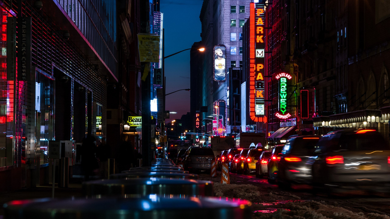 Autos Auf Der Straße Zwischen Hochhäusern Während Der Nacht. Wallpaper in 1280x720 Resolution