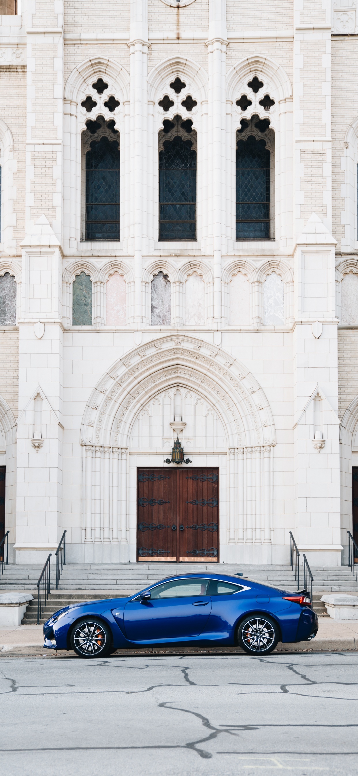 Coupé Bleu Garé à Côté D'un Bâtiment en Béton Blanc Pendant la Journée. Wallpaper in 1242x2688 Resolution