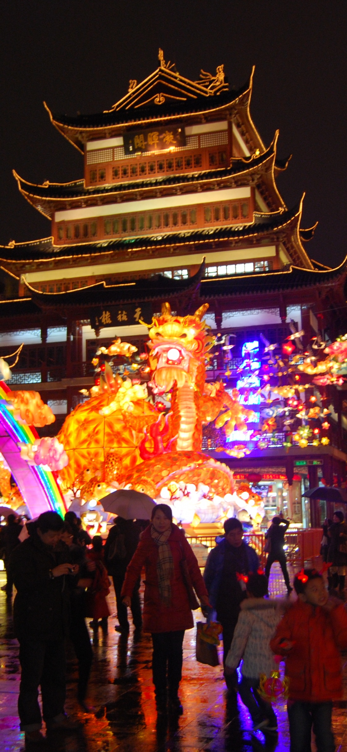 Gente Caminando en la Calle Durante la Noche. Wallpaper in 1125x2436 Resolution