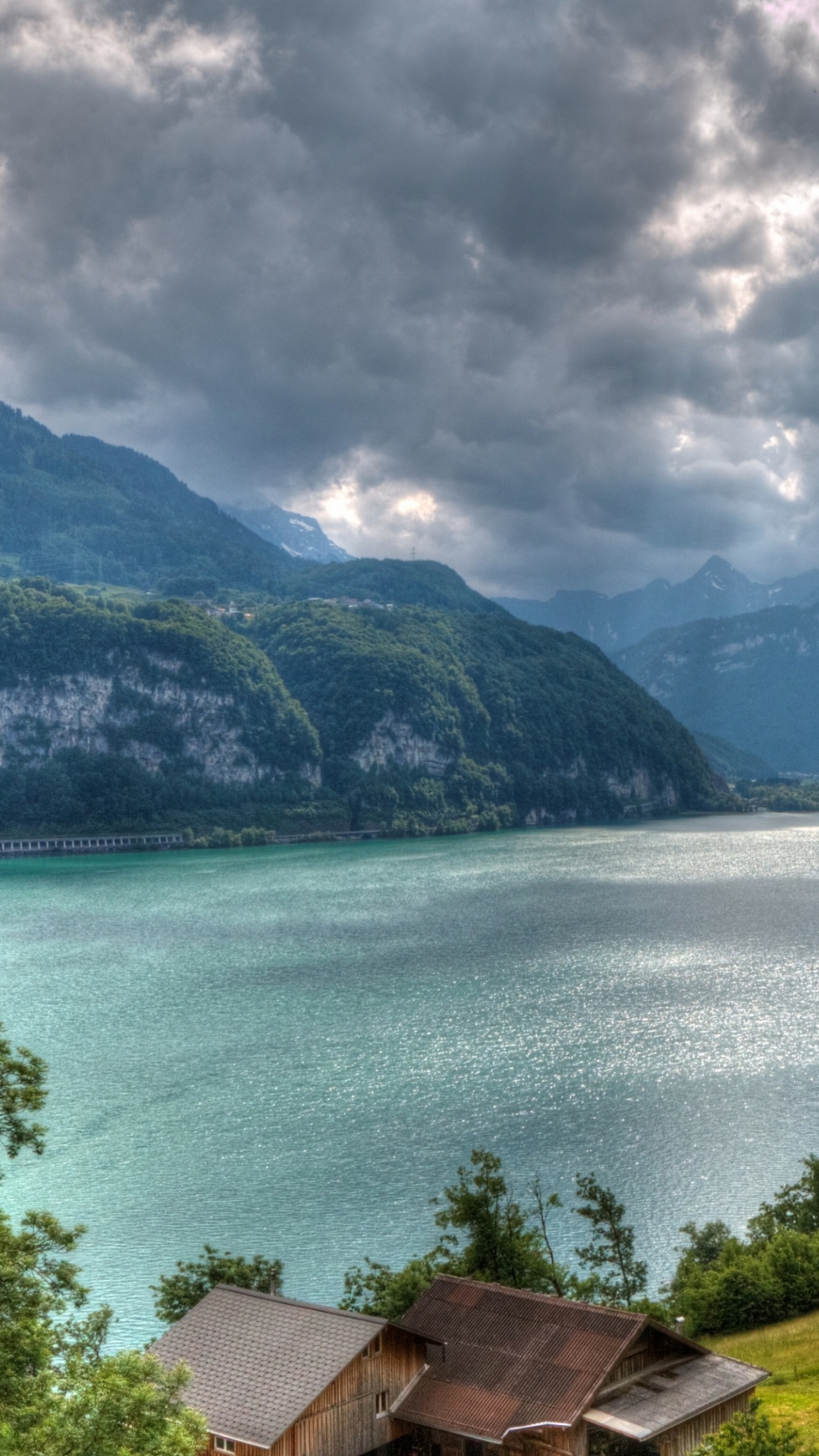 Brown Wooden House Near Green Trees and Body of Water Under Cloudy Sky During Daytime. Wallpaper in 1080x1920 Resolution