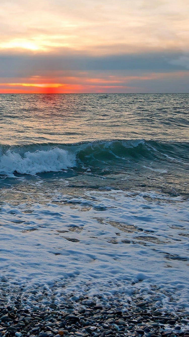 Ocean Waves Crashing on Shore During Sunset. Wallpaper in 750x1334 Resolution