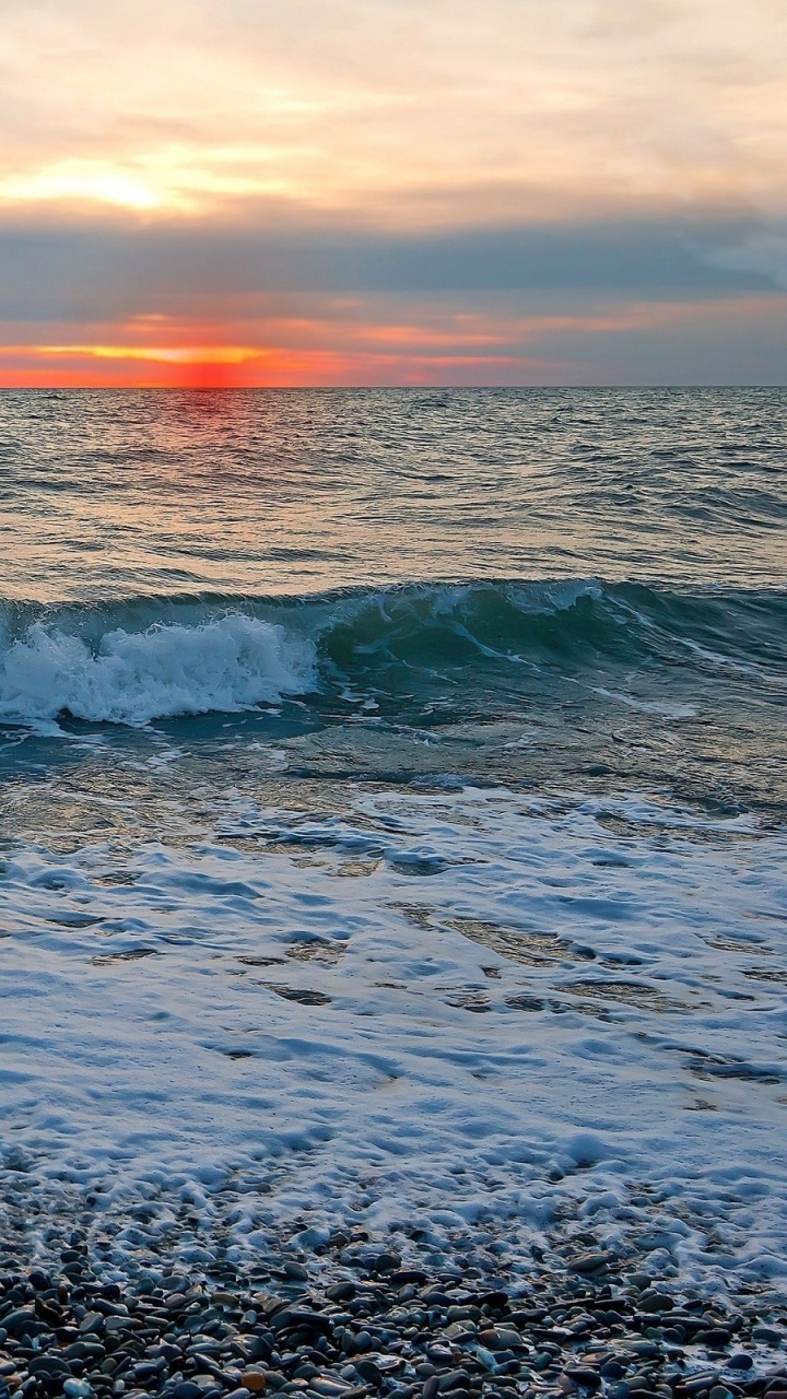 Olas Del Océano Rompiendo en la Orilla Durante la Puesta de Sol. Wallpaper in 720x1280 Resolution