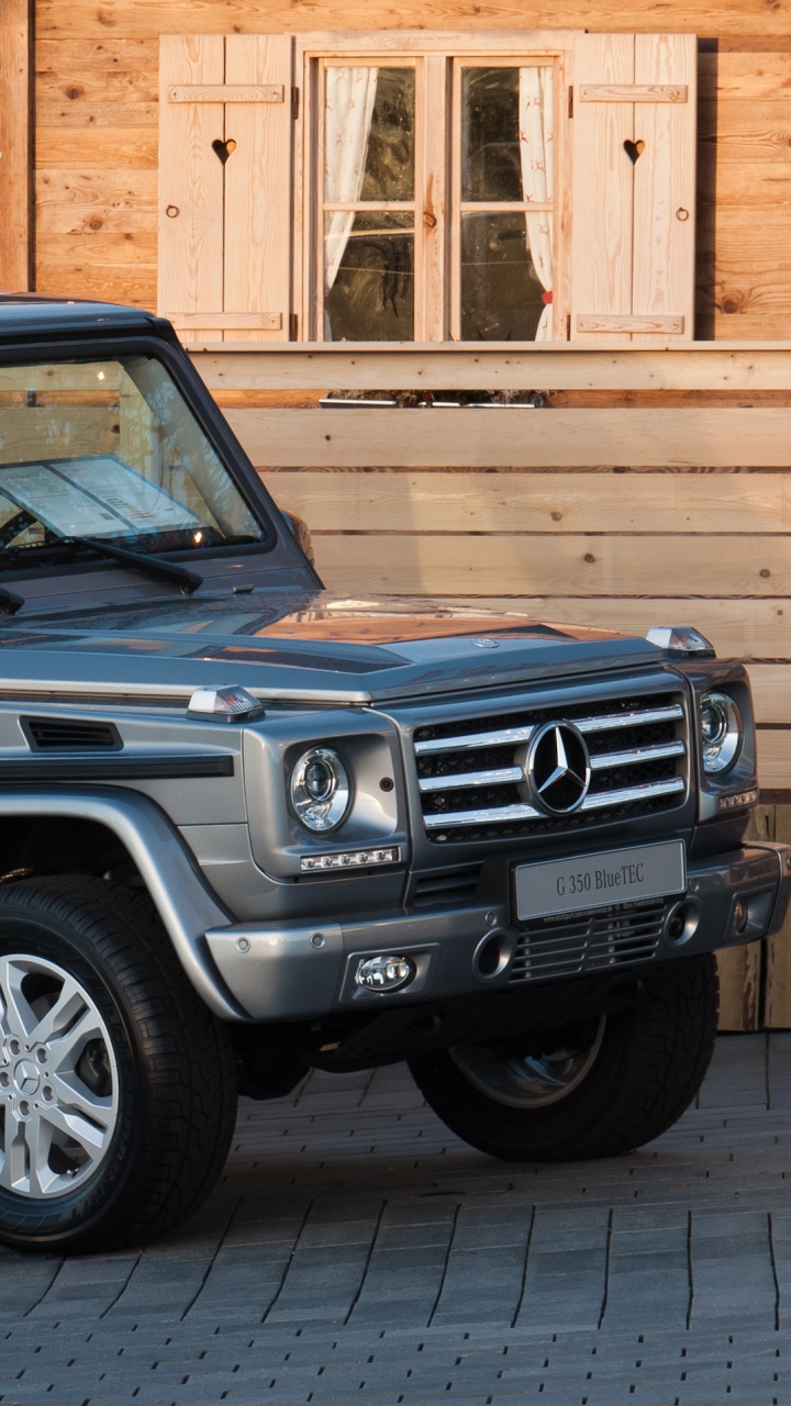 Blue Suv Parked Beside Brown Concrete Building During Daytime. Wallpaper in 720x1280 Resolution