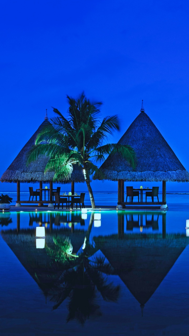 Braunes Holzhaus am Gewässer Während Der Nacht. Wallpaper in 720x1280 Resolution