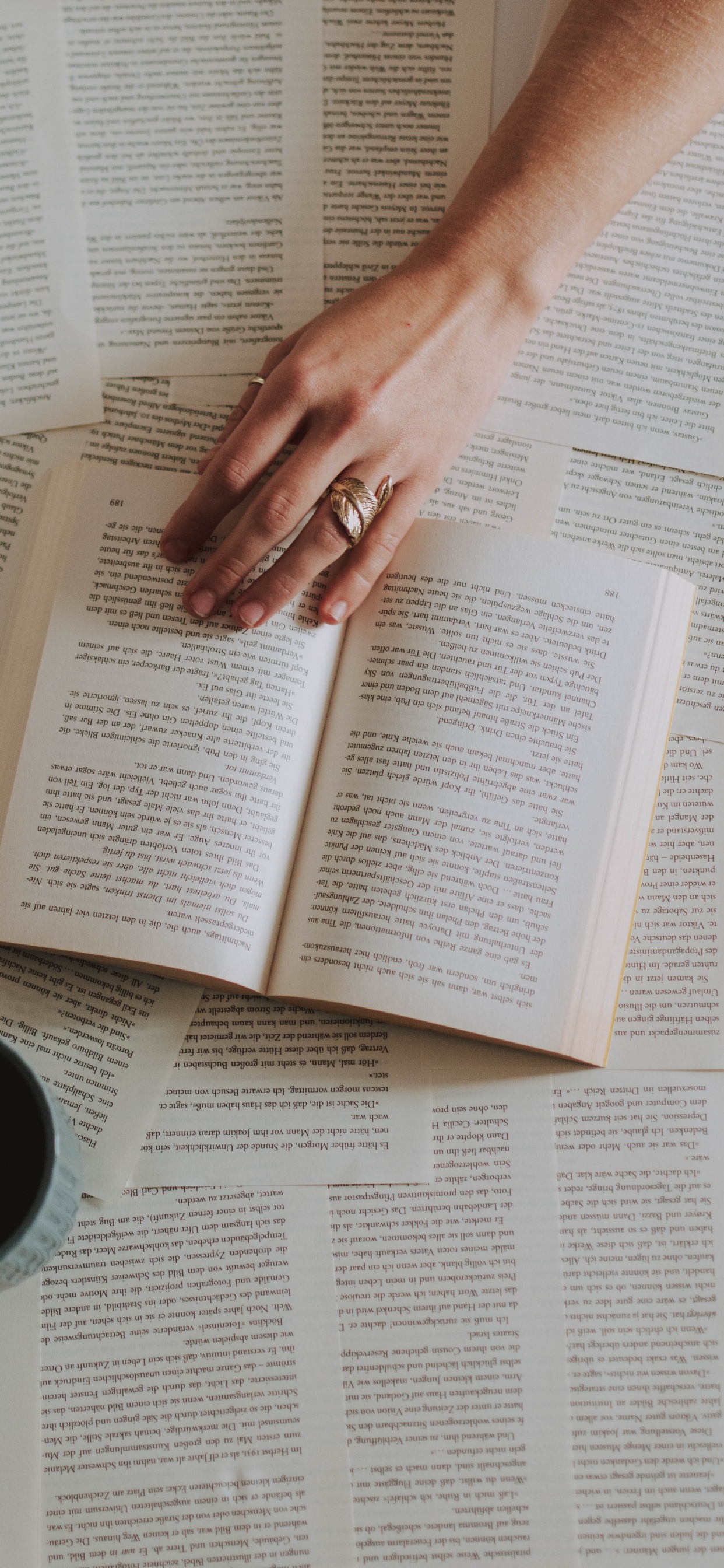 Person Holding White Ceramic Mug on White Book Page. Wallpaper in 1242x2688 Resolution