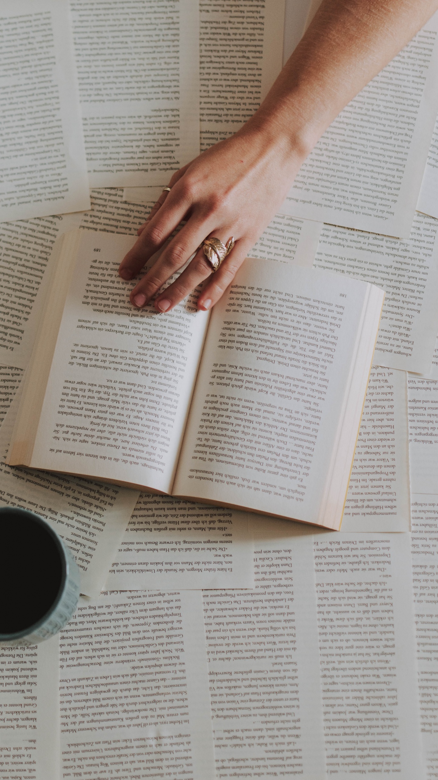 Person Holding White Ceramic Mug on White Book Page. Wallpaper in 1440x2560 Resolution