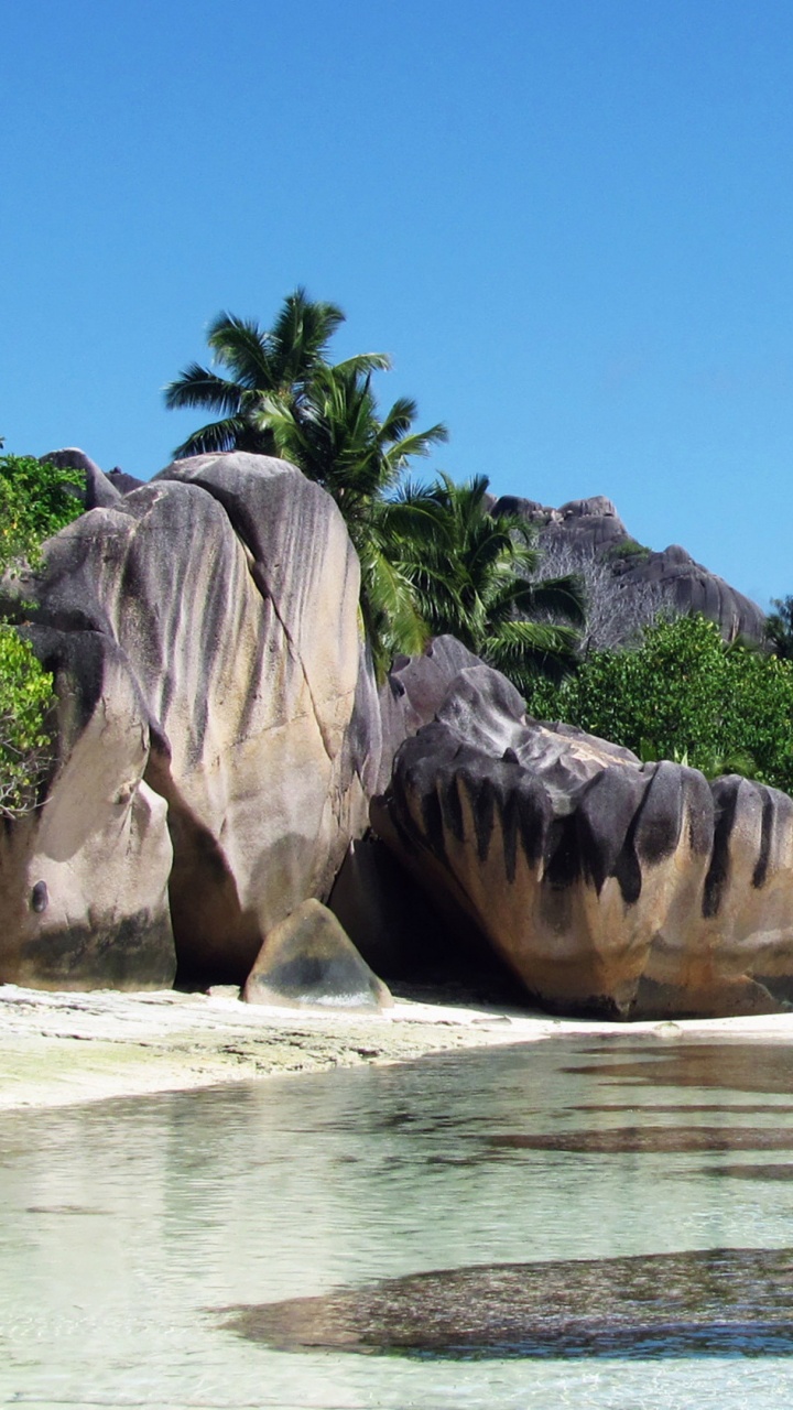Gray Rock Formation Near Body of Water During Daytime. Wallpaper in 720x1280 Resolution
