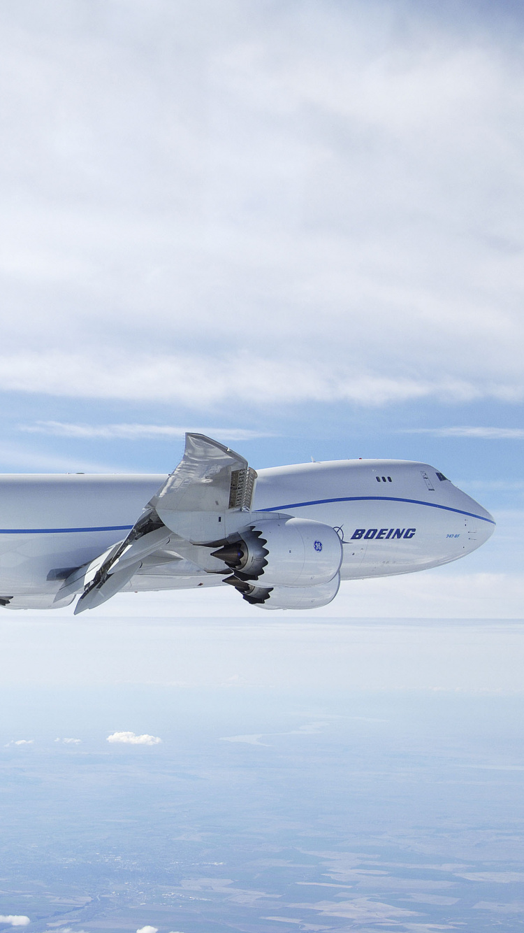 Weißes Und Blaues Flugzeug, Das Tagsüber Über Weiße Wolken Fliegt. Wallpaper in 750x1334 Resolution