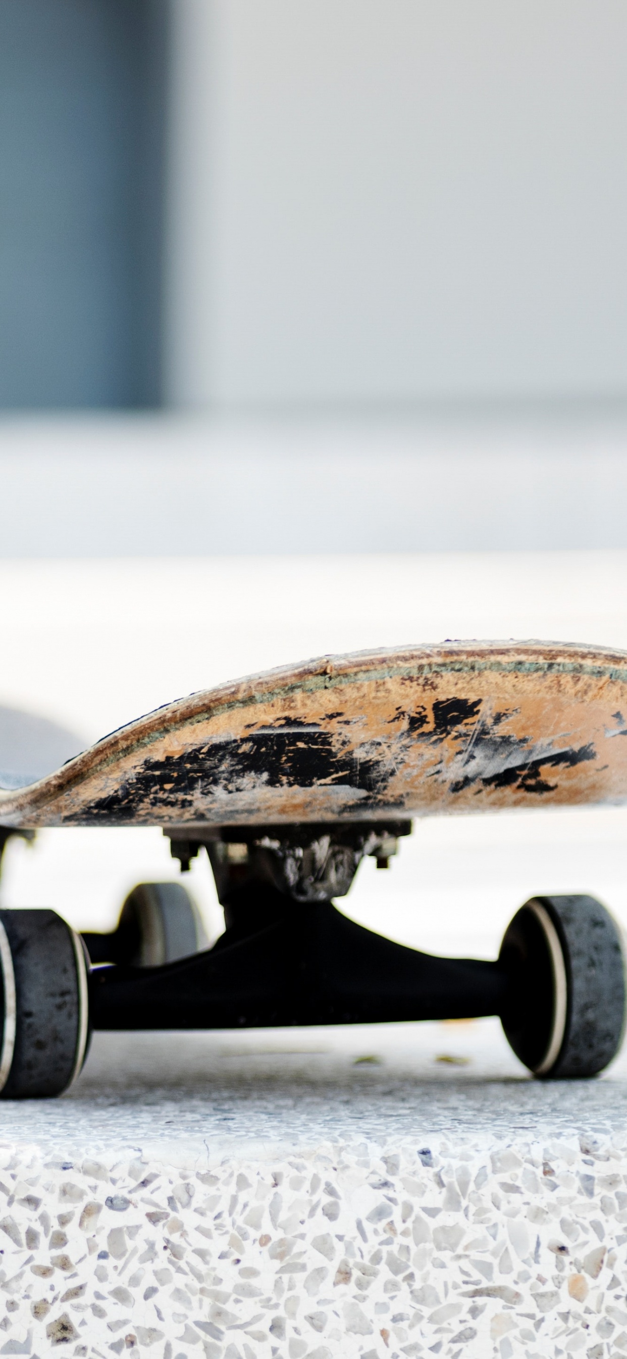 Braunes Und Schwarzes Skateboard Auf Grauem Betonboden. Wallpaper in 1242x2688 Resolution