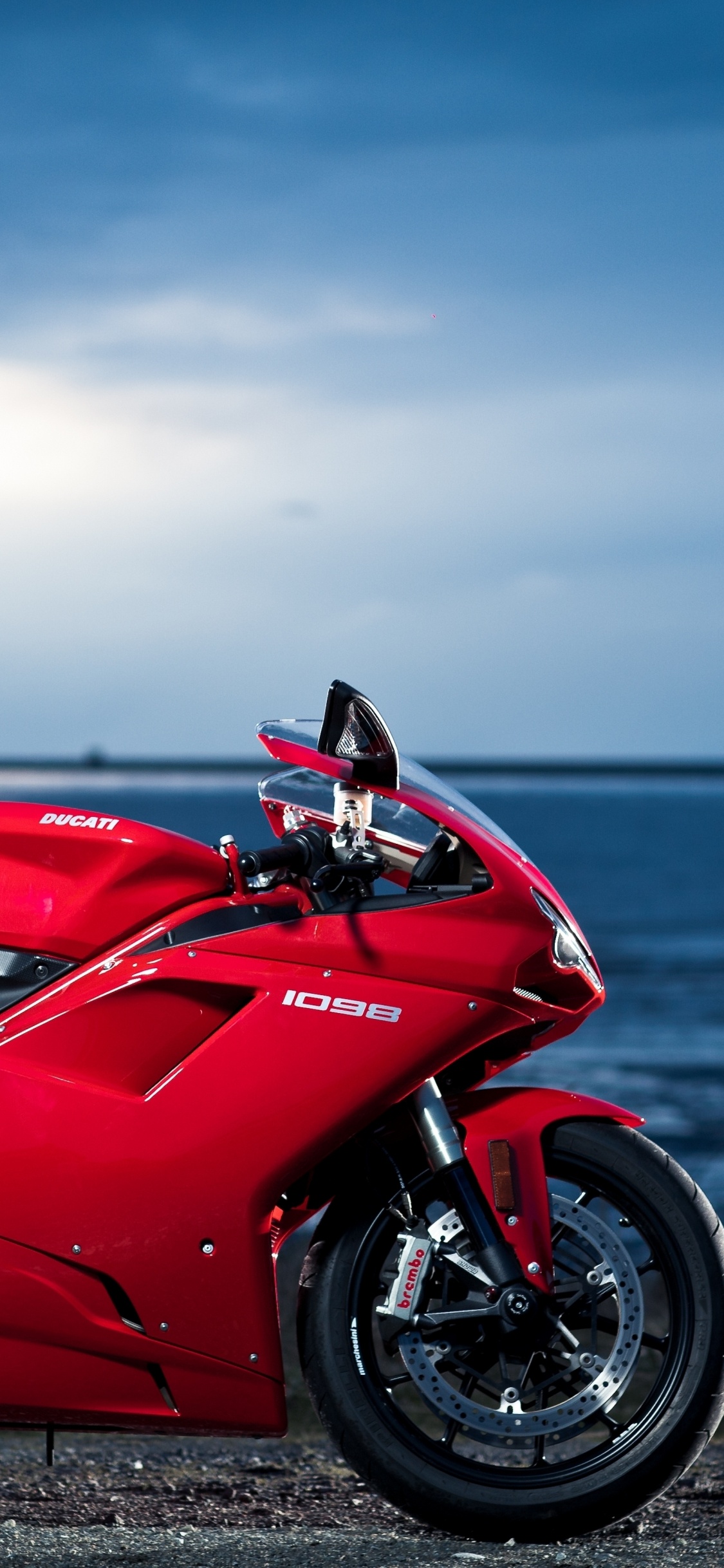 Red and Black Sports Bike on Seashore During Daytime. Wallpaper in 1125x2436 Resolution