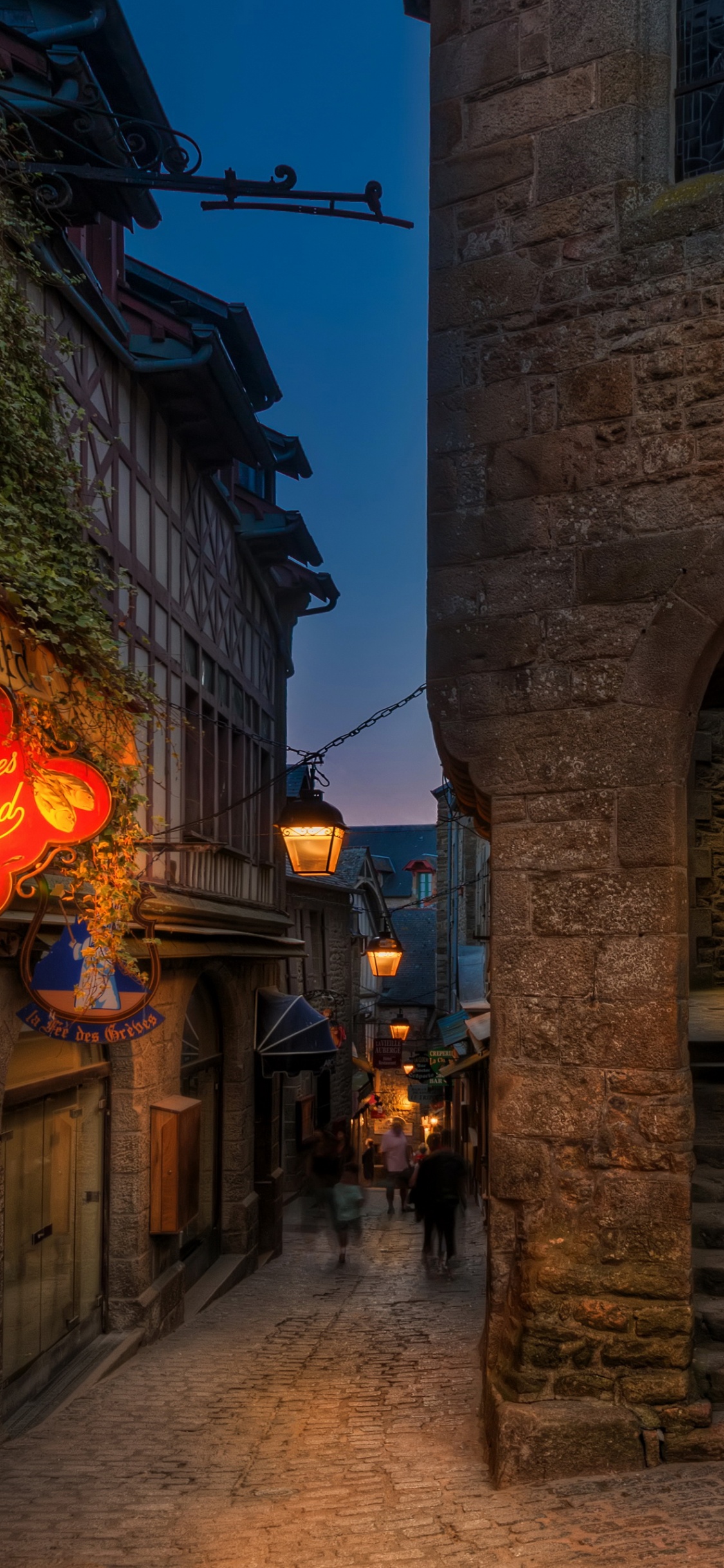 Bâtiment en Briques Brunes Avec Des Lumières Allumées Pendant la Nuit. Wallpaper in 1125x2436 Resolution