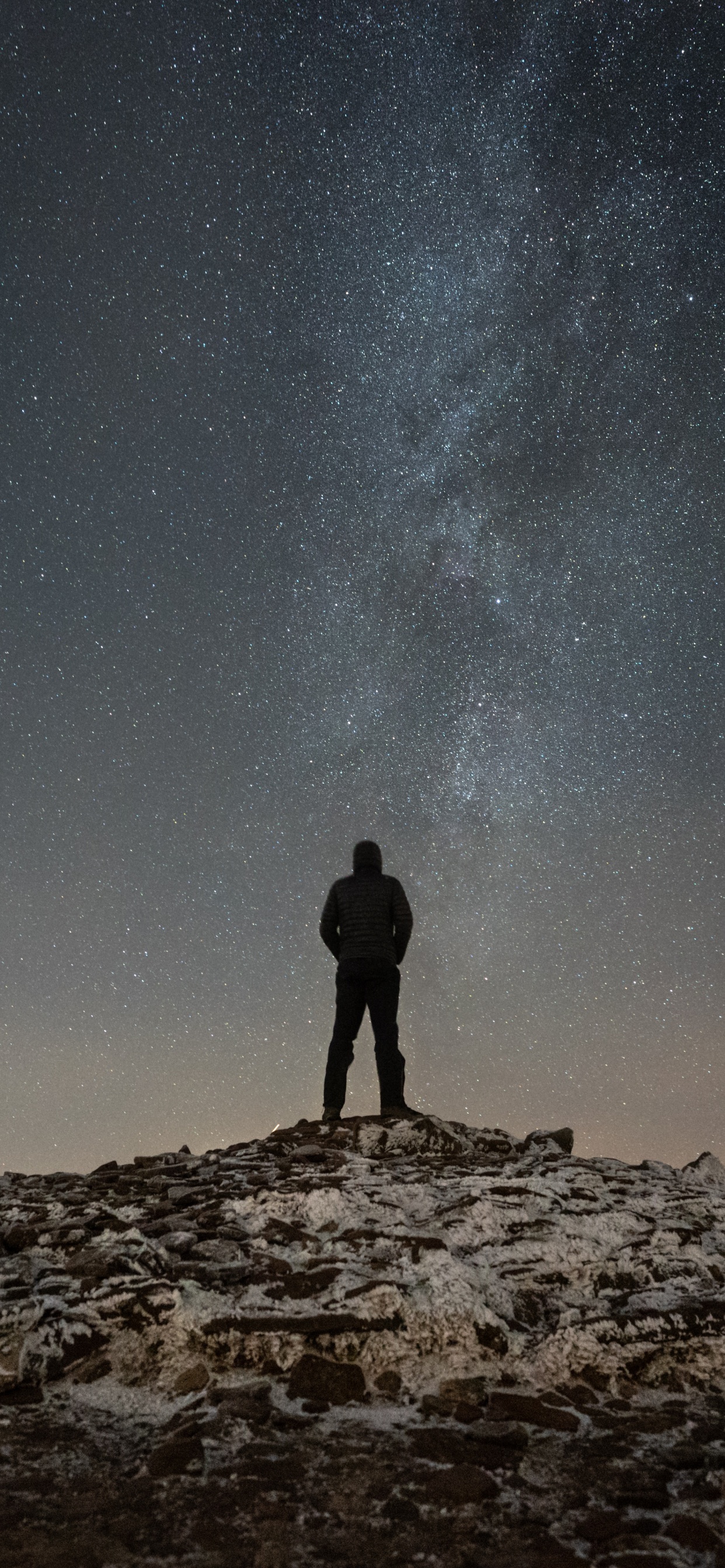 Silhouette of Man Standing on Rocky Hill Under Starry Night. Wallpaper in 1242x2688 Resolution