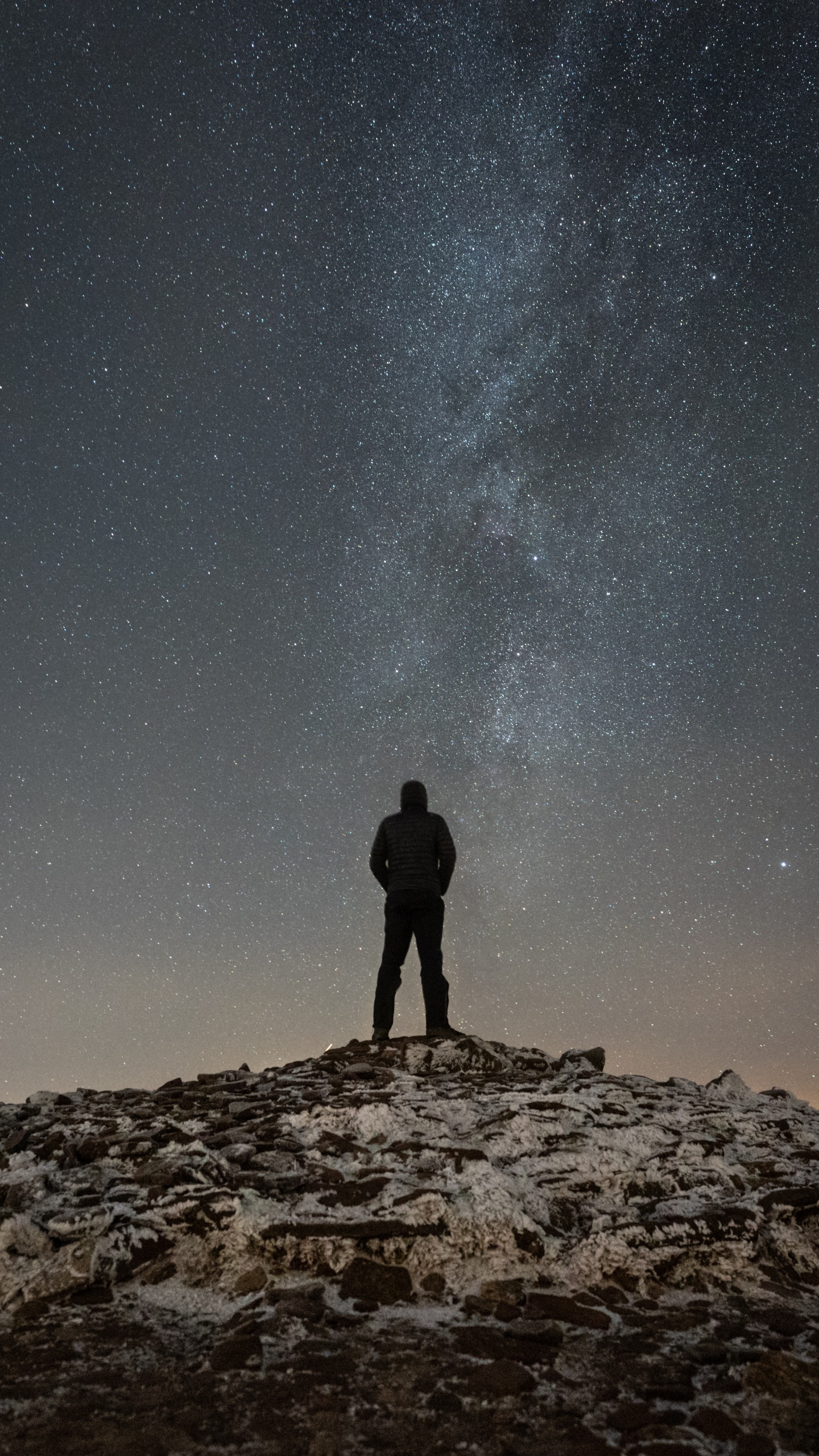 Silhouette of Man Standing on Rocky Hill Under Starry Night. Wallpaper in 1440x2560 Resolution