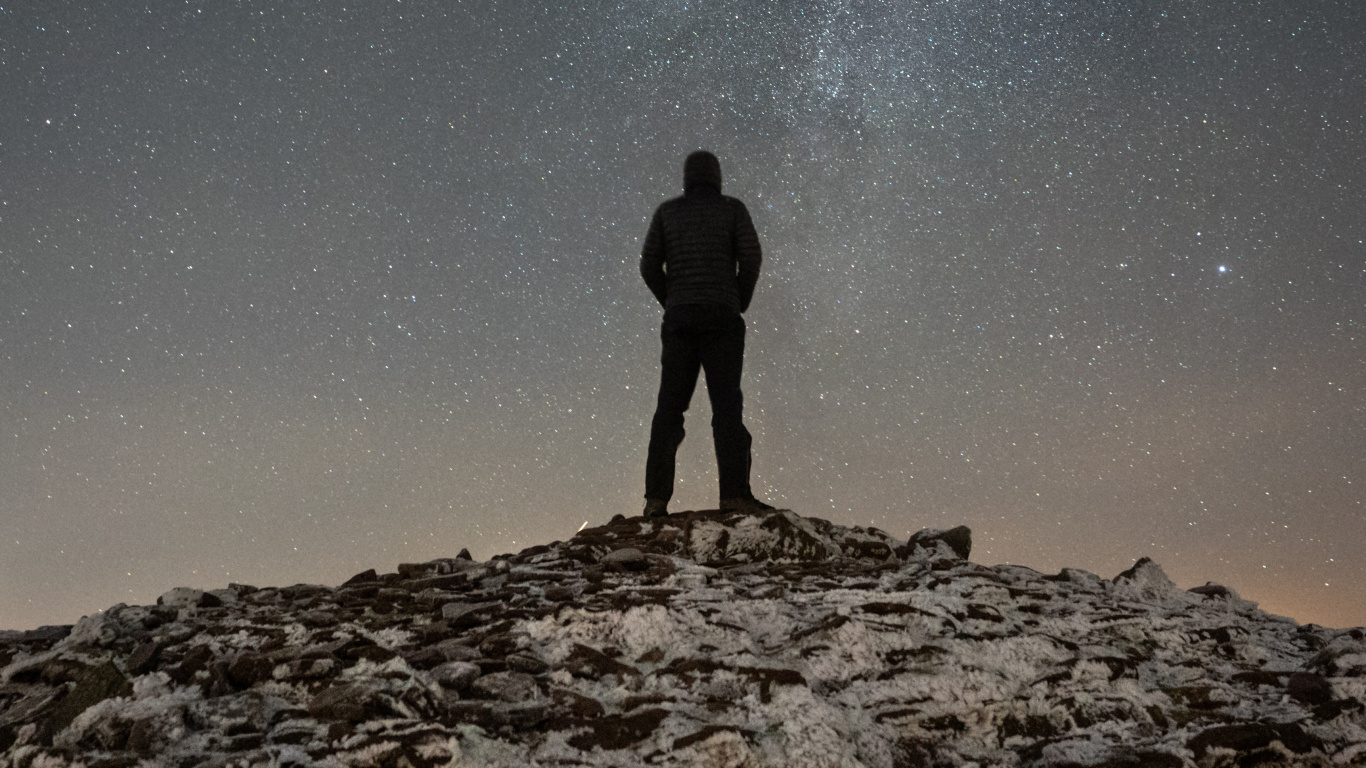 Silueta de Hombre de Pie en la Colina Rocosa Bajo la Noche Estrellada. Wallpaper in 1366x768 Resolution